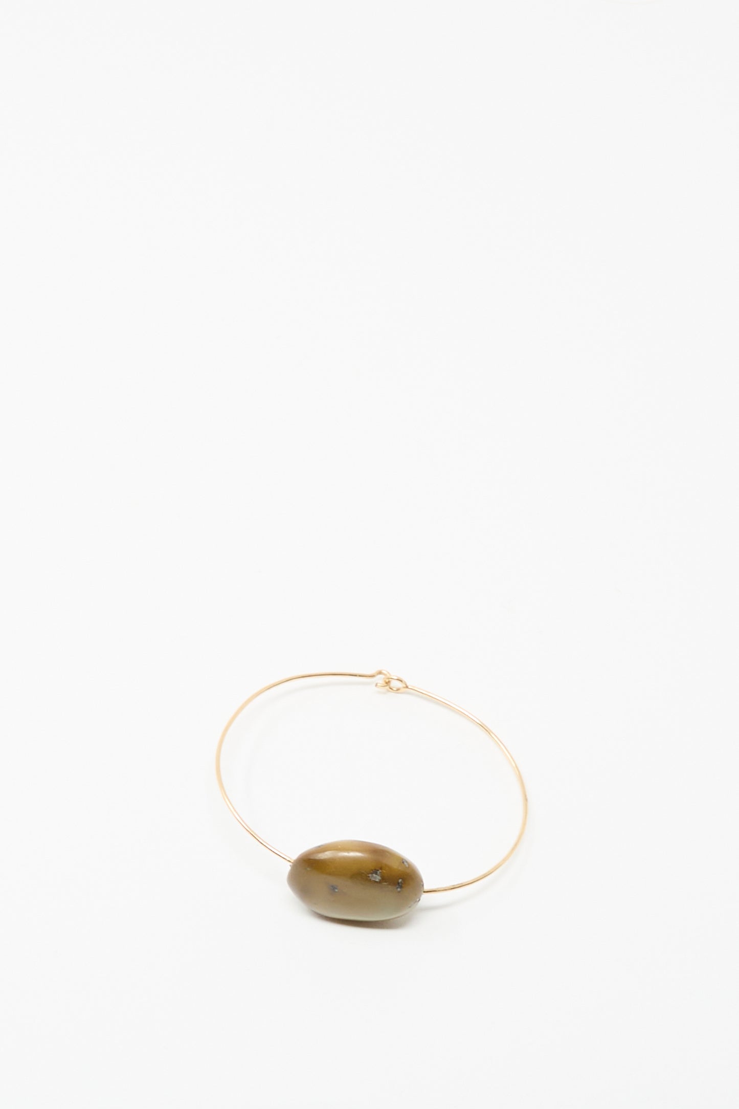 The Mary MacGill Stone Cuff Bracelet features a thin gold-filled wire and a single oval brown turquoise stone, showcased on a plain white background.