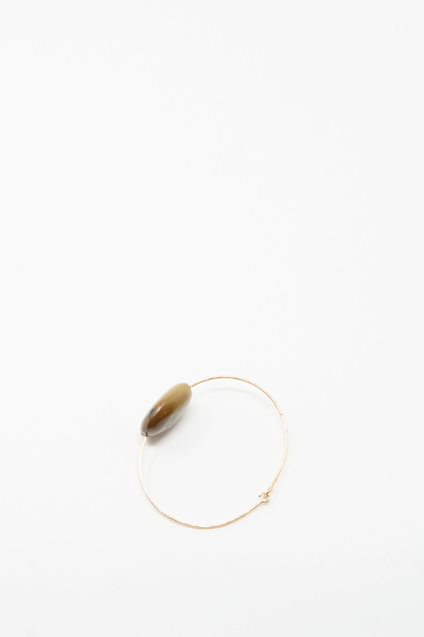The Mary MacGill Stone Cuff Bracelet features a thin gold-filled wire and a single oval brown turquoise stone, showcased on a plain white background.
