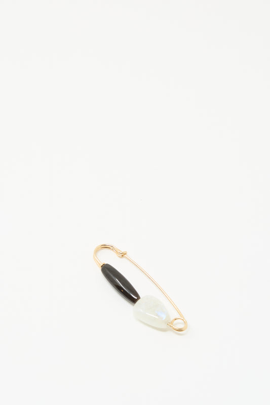 The Moonstone and Agate Pin by Mary MacGill features a gold-filled wire, a black agate bead, and a light moonstone on a plain white background.