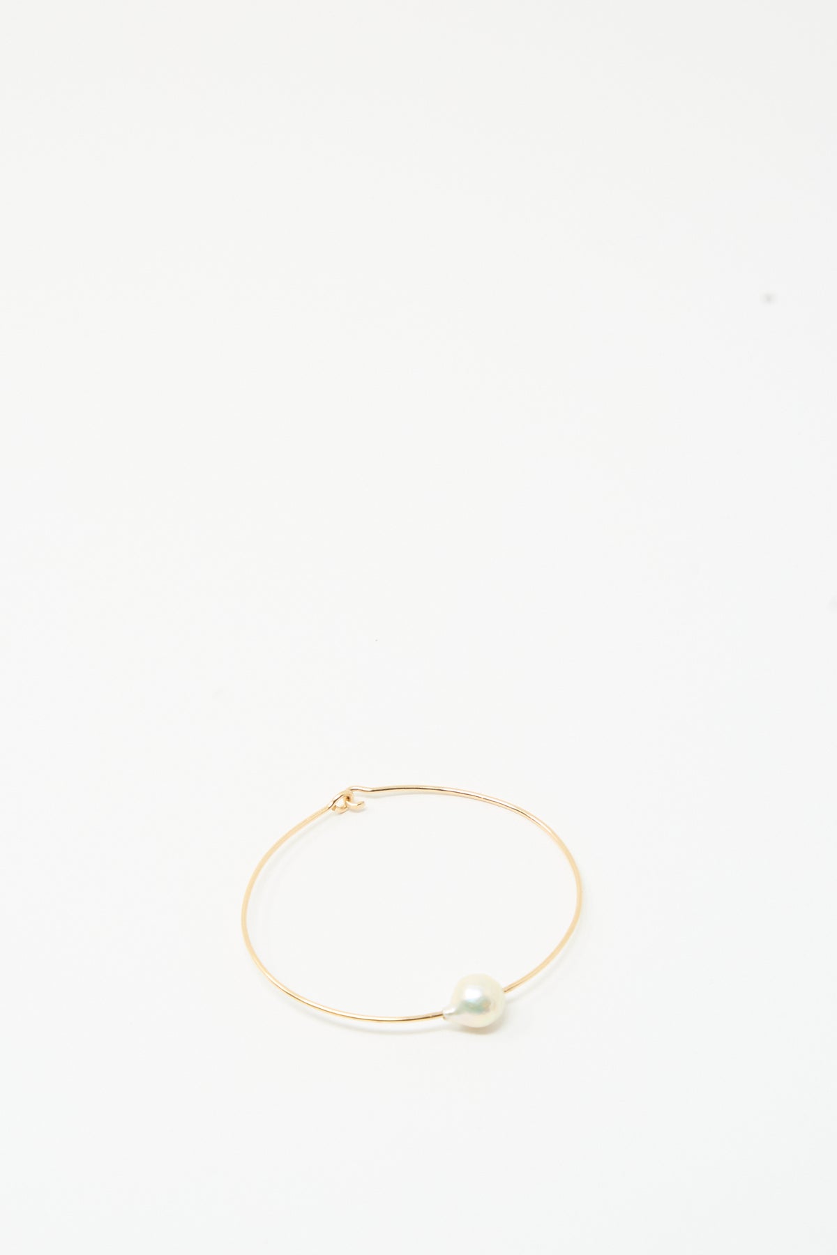 The Mary MacGill Petite Baroque Pearl Cuff in White features a thin gold-filled band with a single round pearl on a plain white background.