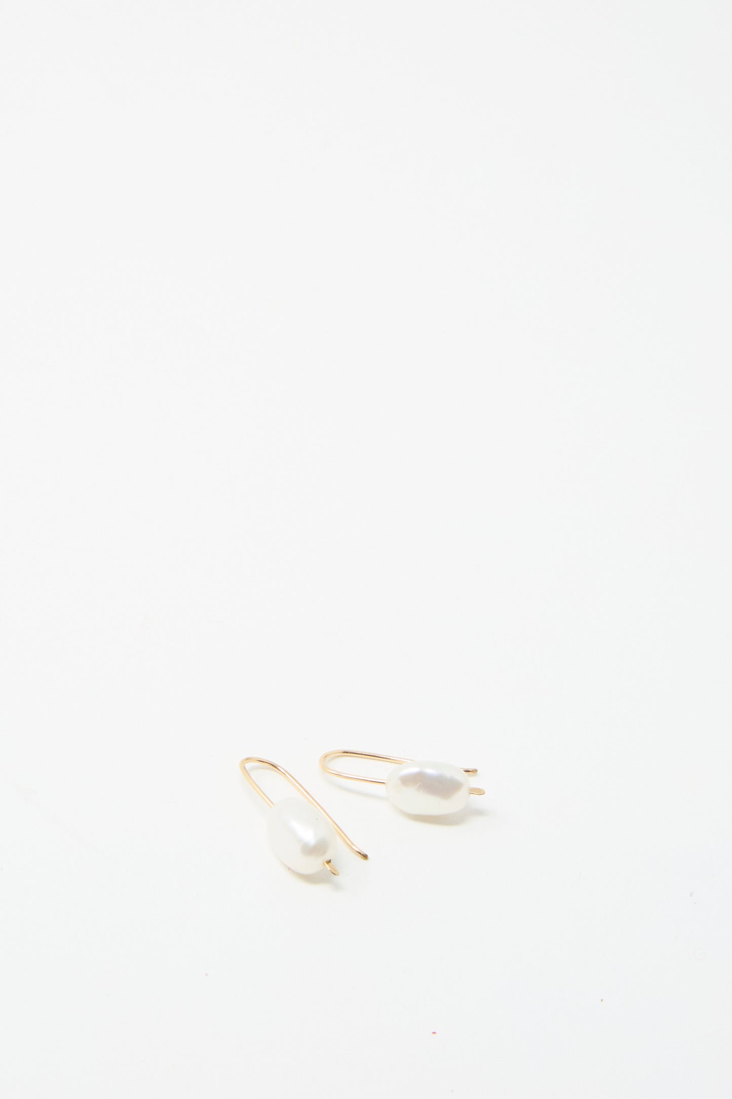 Two exquisite Petite Baroque Pearl Drop Earrings in White by Mary MacGill are beautifully showcased on a white background.