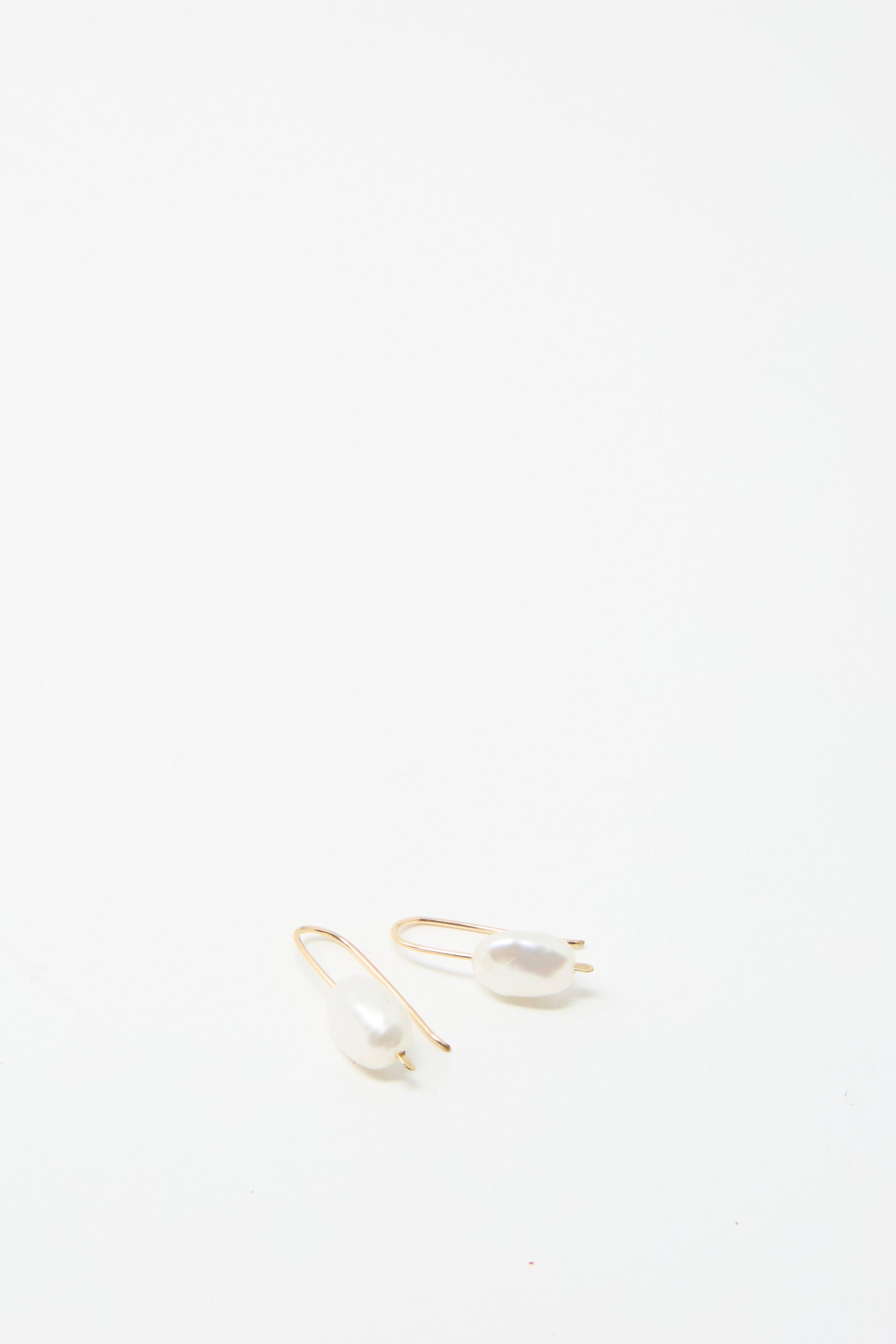 Two exquisite Petite Baroque Pearl Drop Earrings in White by Mary MacGill are beautifully showcased on a white background.