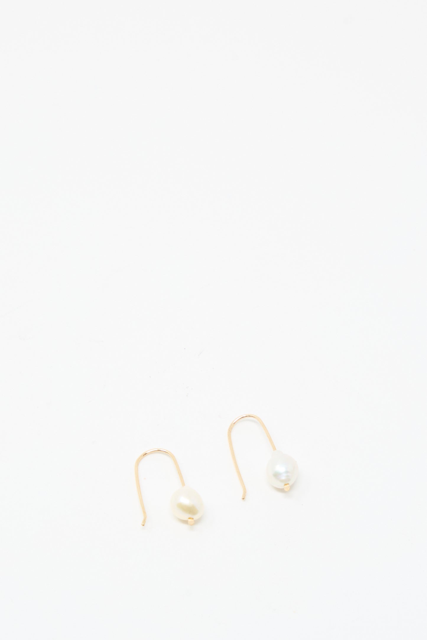 The Mary MacGill Petite Baroque Pearl Drop Earrings in White are handmade, gold-filled earrings featuring white pearls, shown against a plain white background.