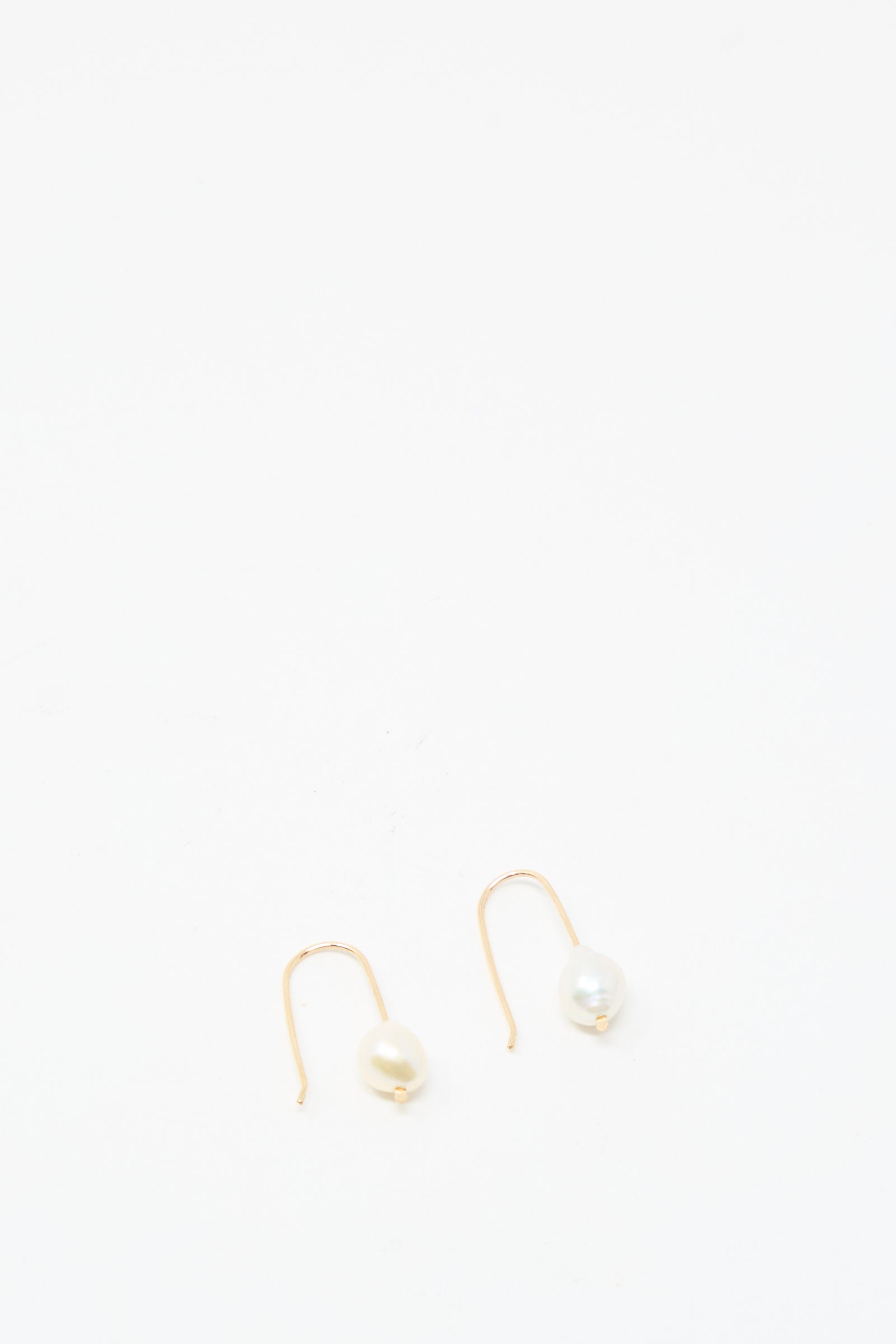 The Mary MacGill Petite Baroque Pearl Drop Earrings in White are handmade, gold-filled earrings featuring white pearls, shown against a plain white background.