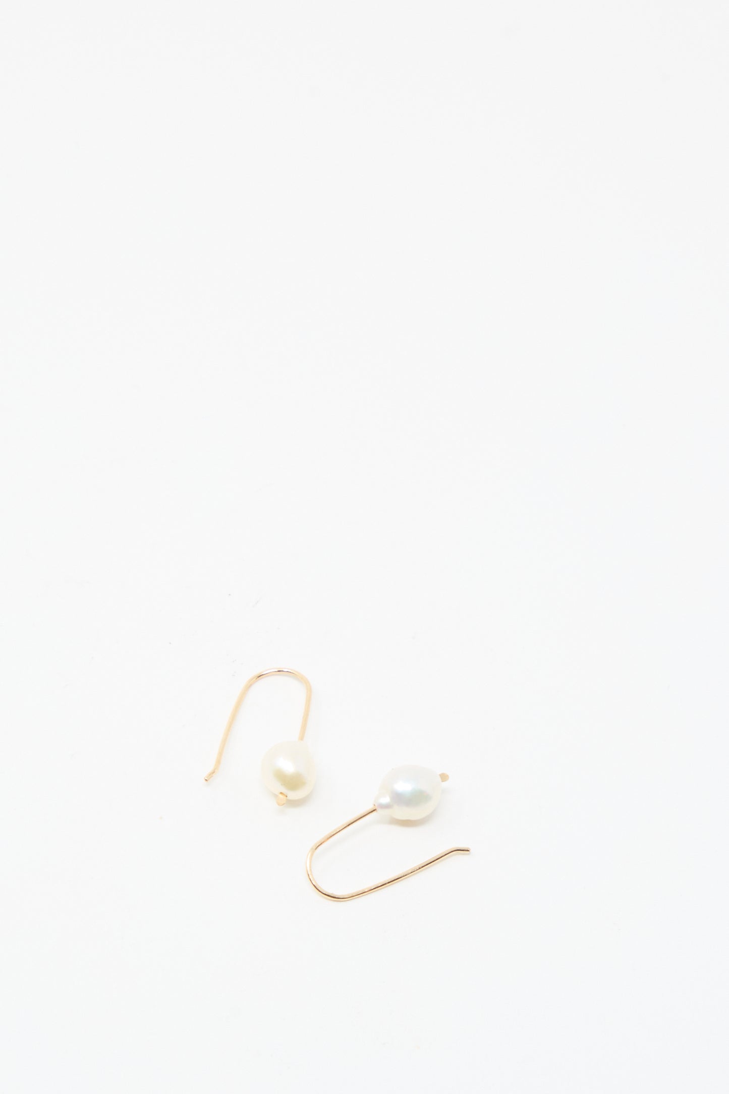 The Petite Baroque Pearl Drop Earrings in White by Mary MacGill are displayed on a plain white background, highlighting the elegance of their gold-filled design and distinctive baroque pearls.