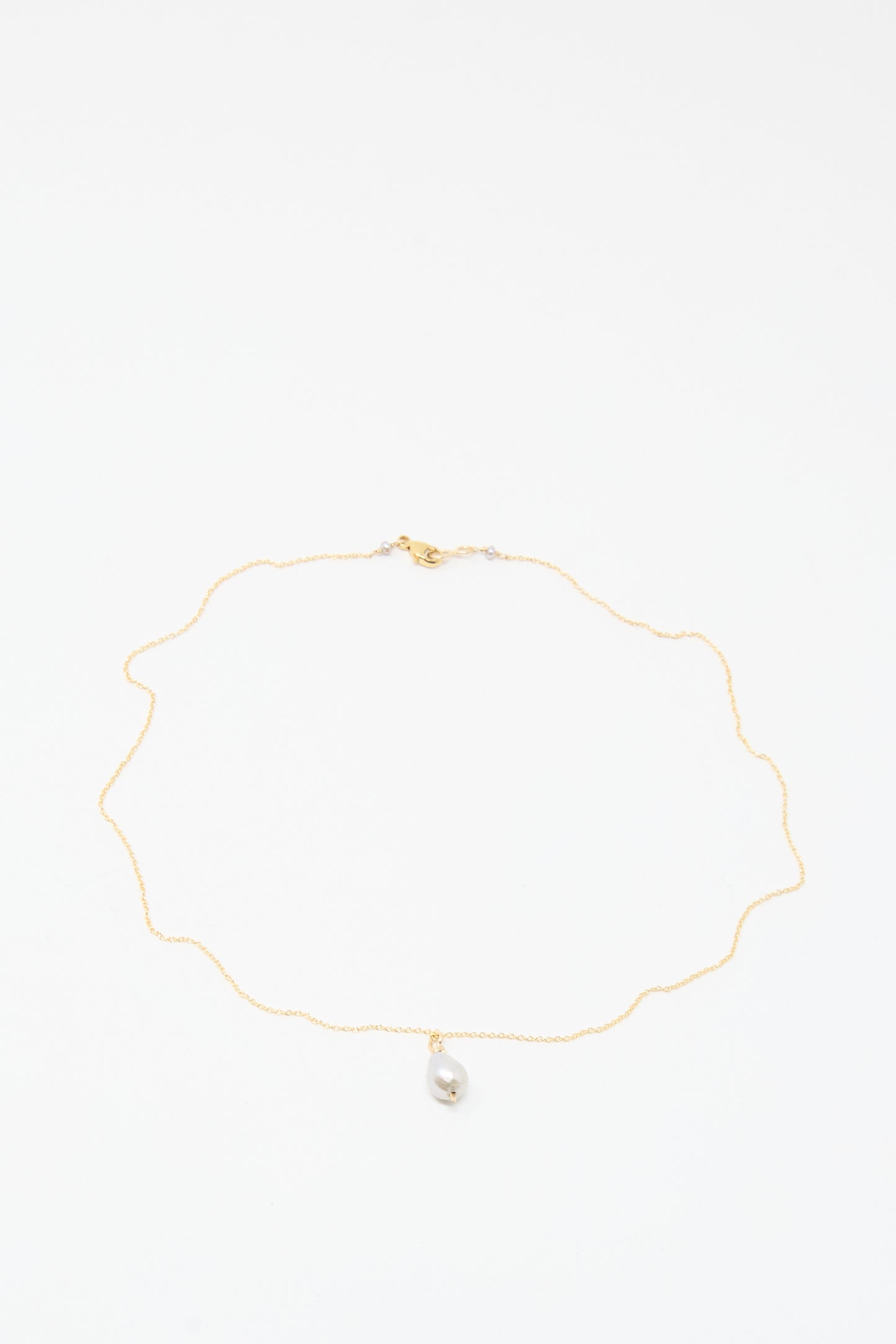 The Mary MacGill Petite Baroque Pearl Drop Necklace in Silver features a single small baroque pearl pendant on a delicate handmade chain, displayed on a white background.