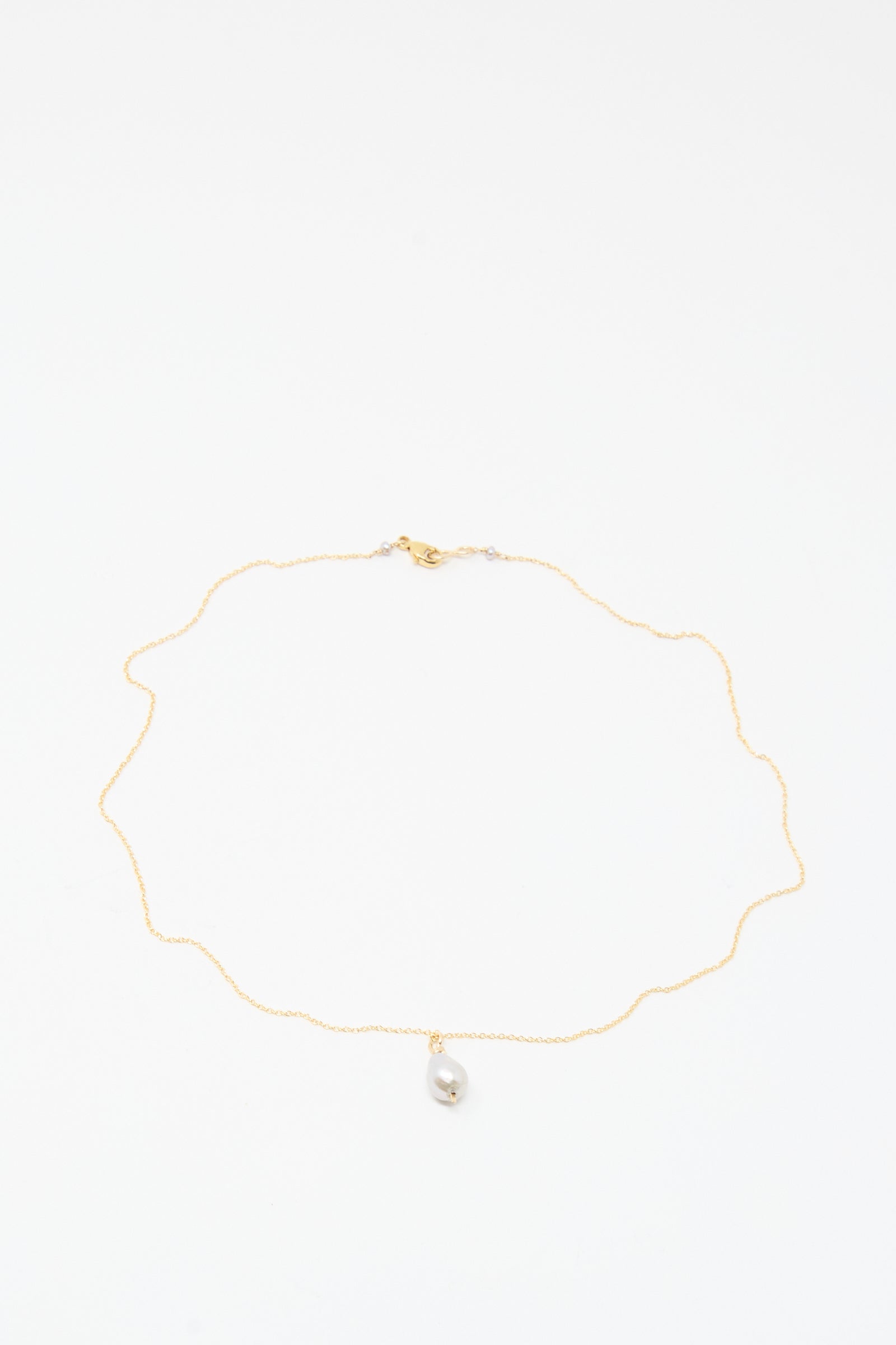 The Mary MacGill Petite Baroque Pearl Drop Necklace in Silver features a single small baroque pearl pendant on a delicate handmade chain, displayed on a white background.
