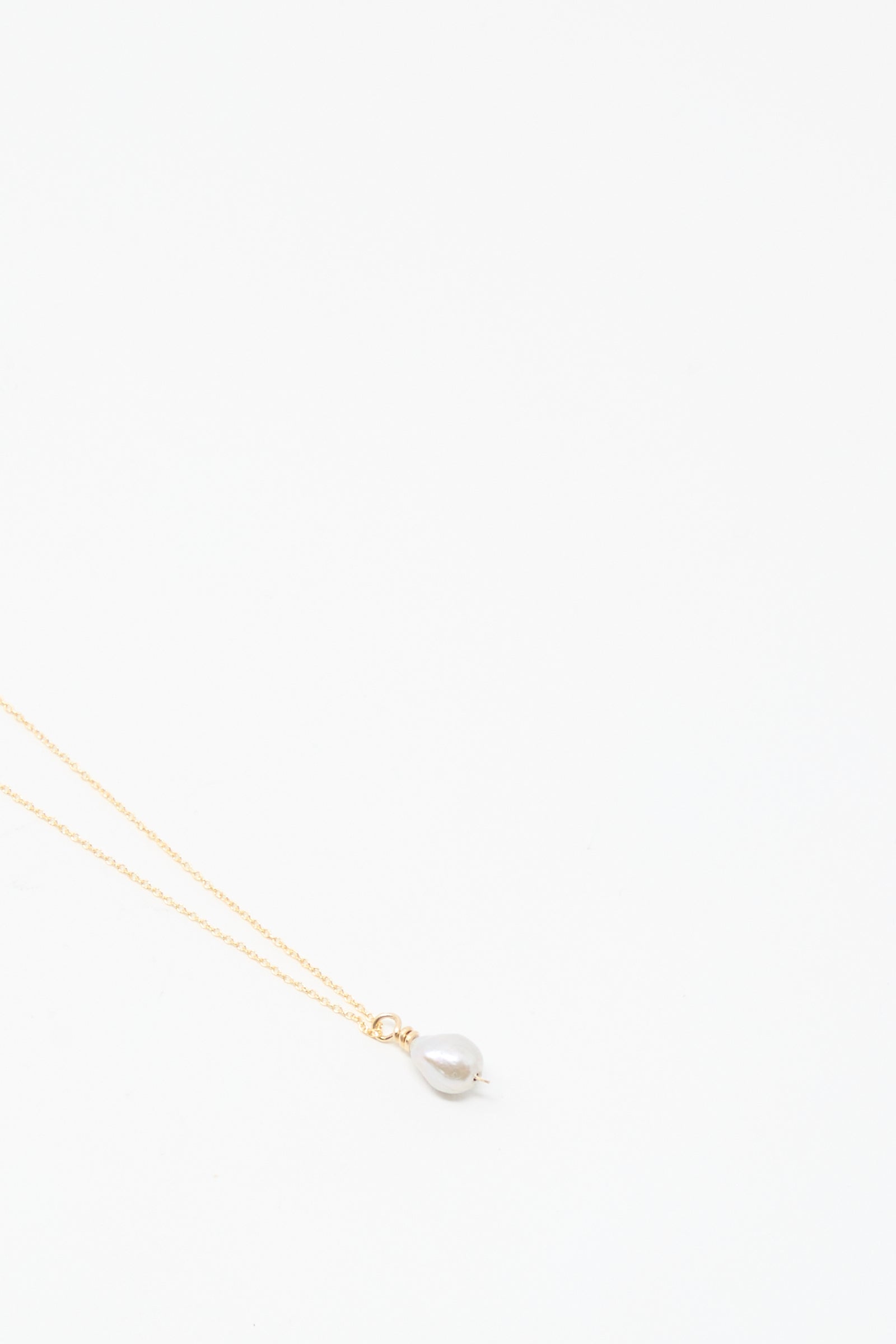 The Mary MacGill Petite Baroque Pearl Drop Necklace in Silver is handmade and features a single baroque pearl pendant, shown on a plain white background.