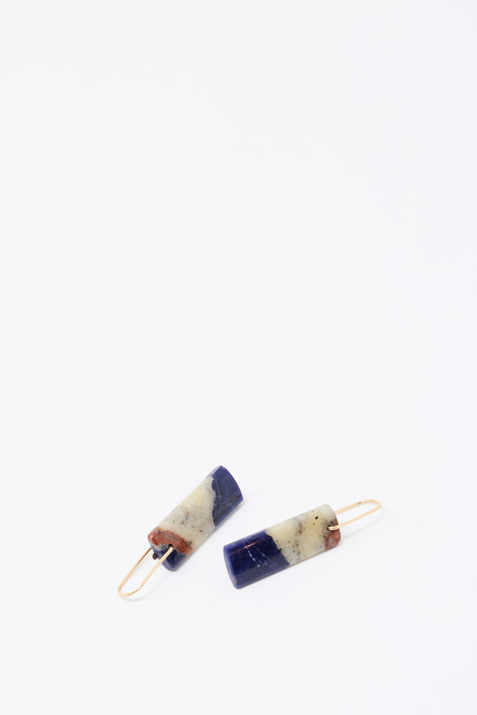 Mary MacGill Stone Drop Earrings in Sodalite feature rectangular handmade drops with gold hooks and a navy blue, cream, and brown color block pattern, shown on a white background.