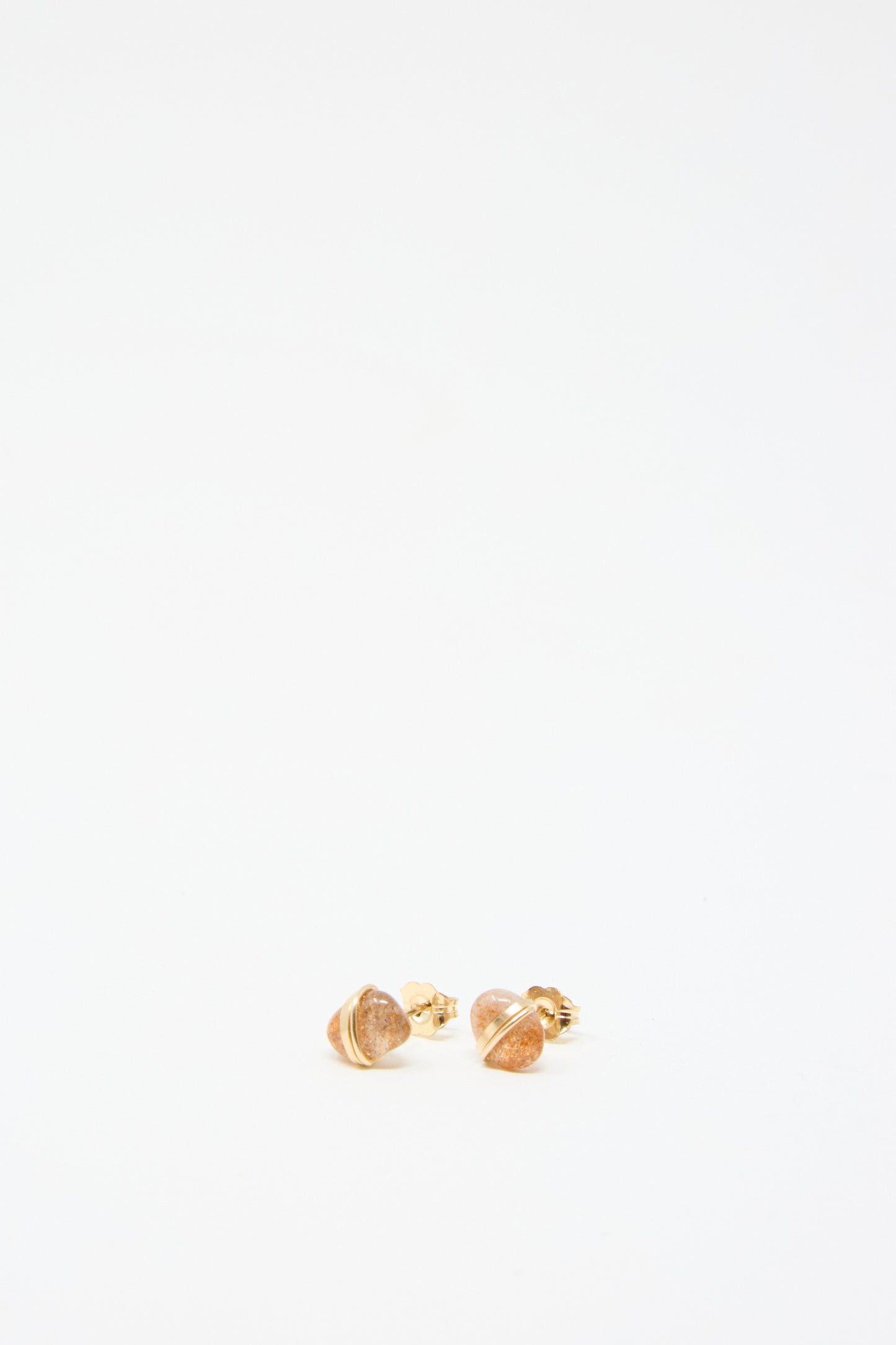 A pair of Stone Studs in Sunstone by Mary MacGill, stud earrings with intricate gold-filled wire detailing, set against a plain white background.