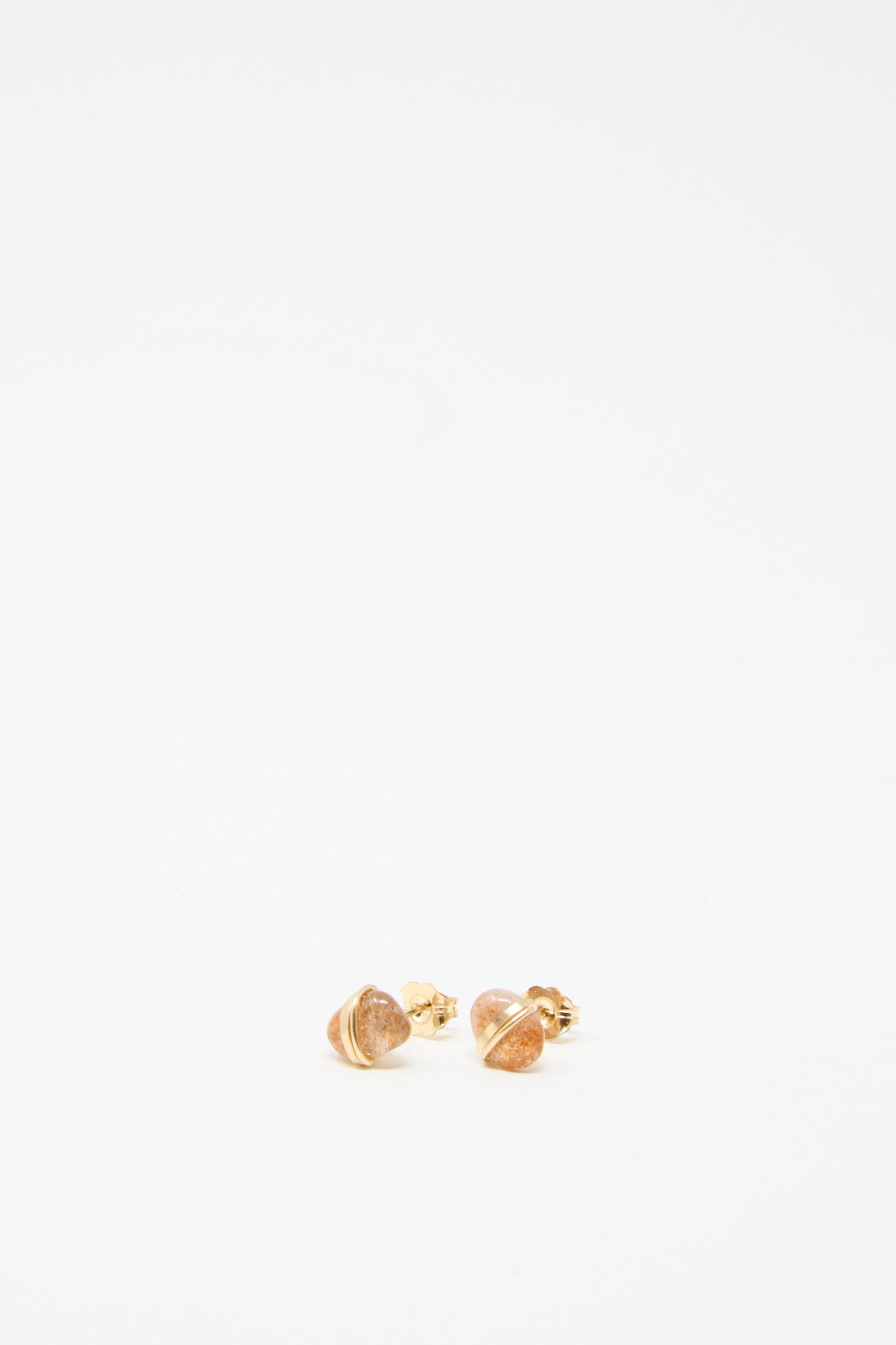 A pair of Stone Studs in Sunstone by Mary MacGill, stud earrings with intricate gold-filled wire detailing, set against a plain white background.