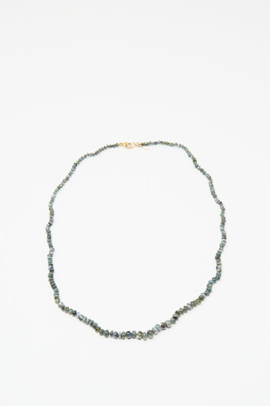 The Mary MacGill 14K Stone Layering Necklace in Cat's Eye features small, irregular green stones and a 14k gold clasp, shown on a white background.