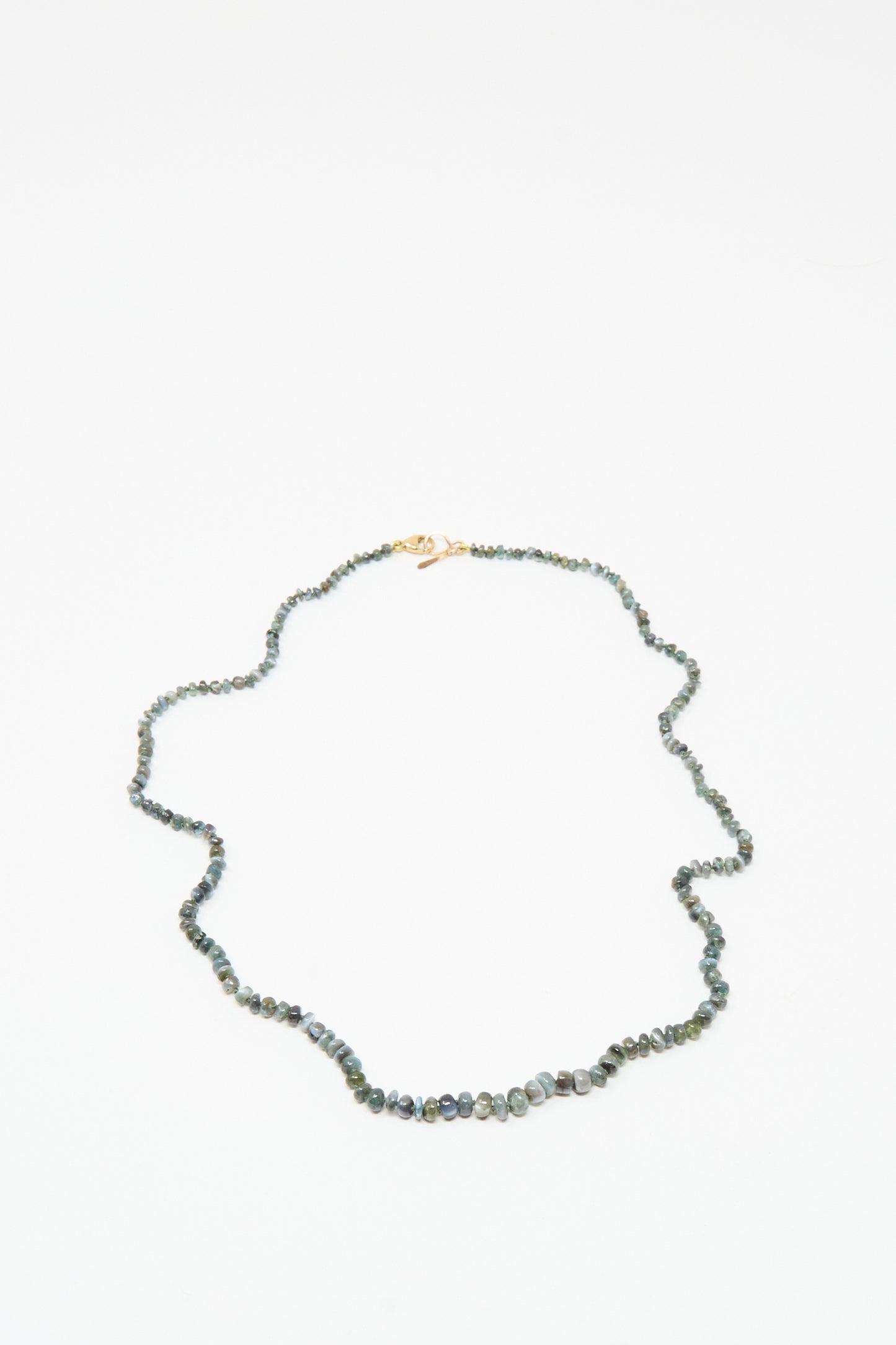 The Mary MacGill 14K Stone Layering Necklace in Cat's Eye features small, irregular dark green and gray beads with a 14k gold clasp, showcased on a white background.