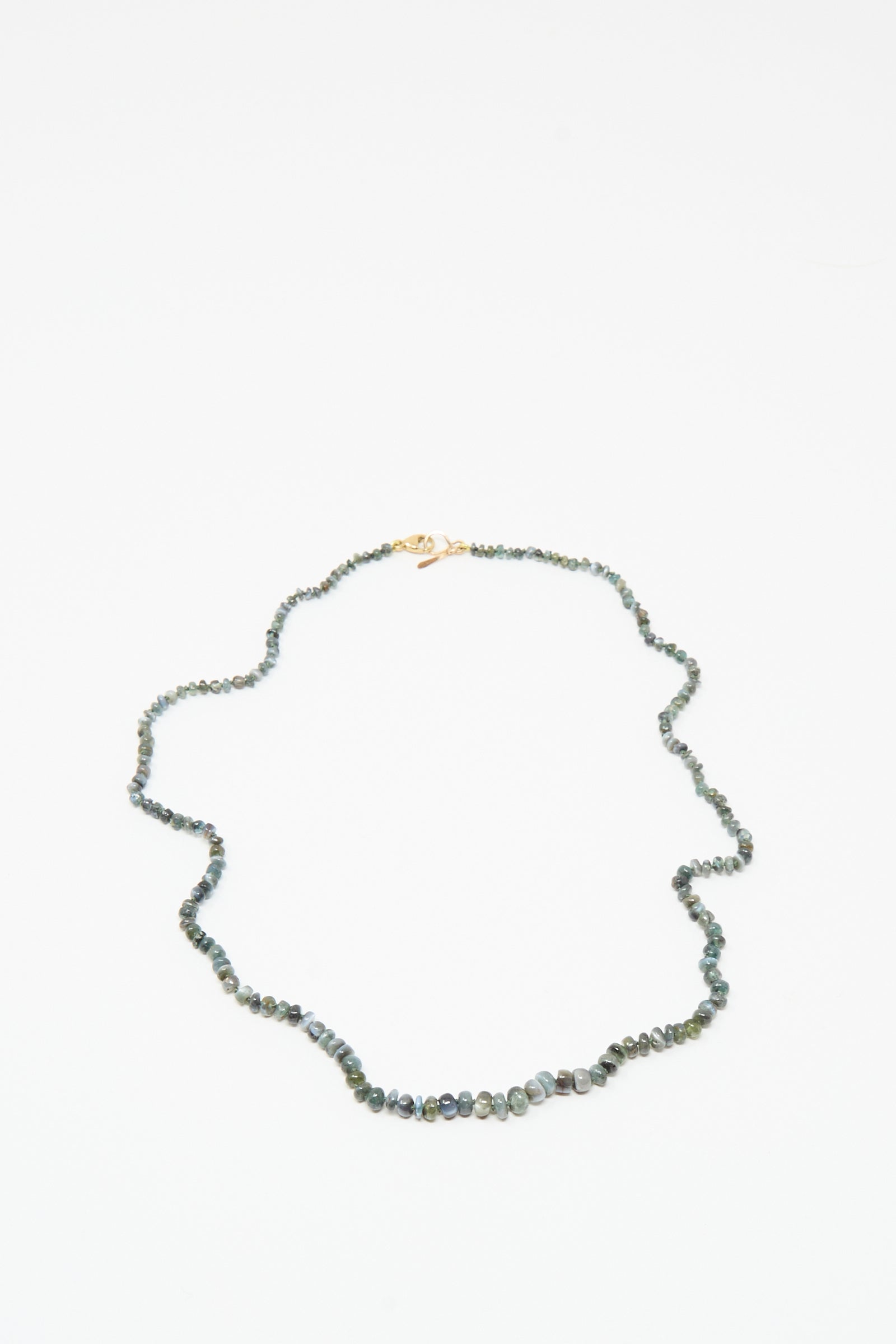 The Mary MacGill 14K Stone Layering Necklace in Cat's Eye features small, irregular dark green and gray beads with a 14k gold clasp, showcased on a white background.