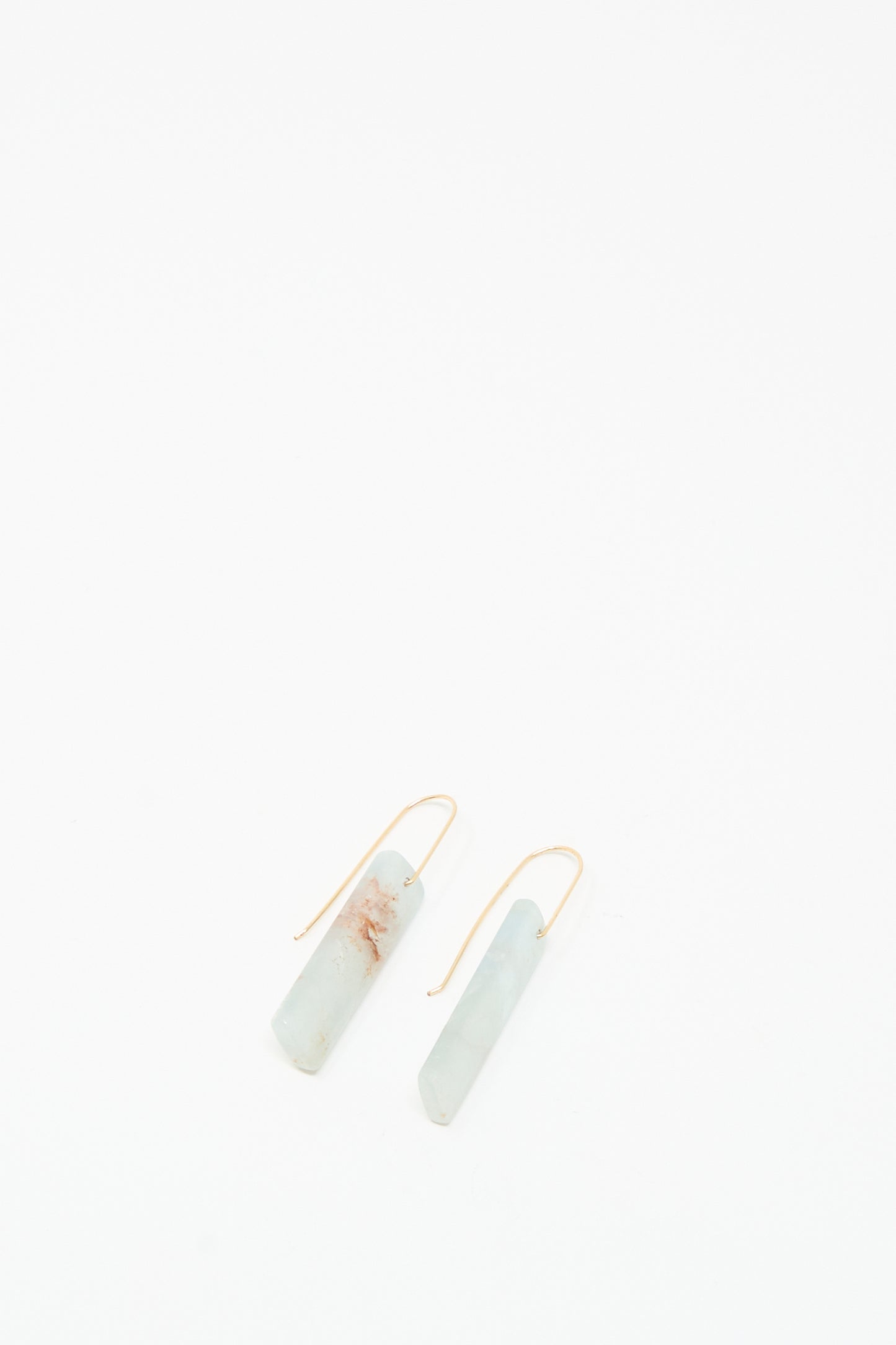 The Stone Drop Earrings in Blue Calcite Rectangular Stone by Mary MacGill feature minimalist light blue stones and 14k gold-filled hooks, shown on a white background.