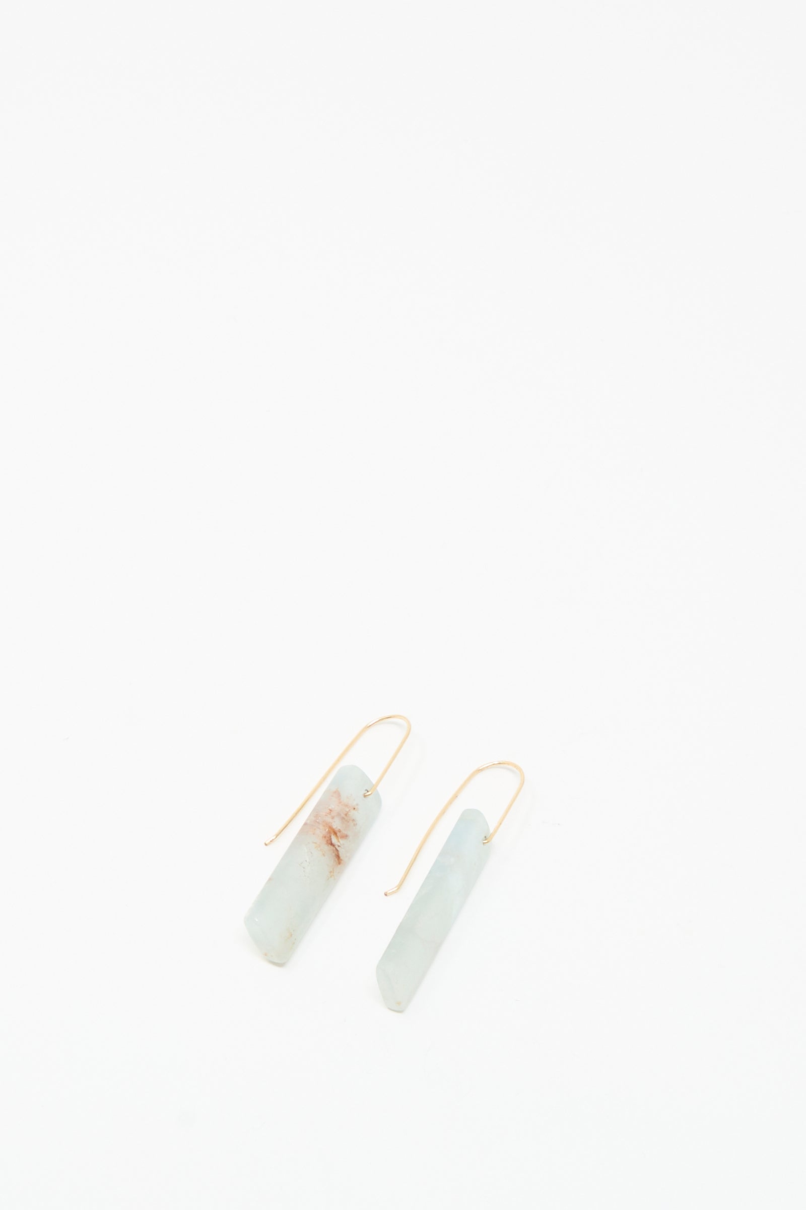 The Stone Drop Earrings in Blue Calcite Rectangular Stone by Mary MacGill feature minimalist light blue stones and 14k gold-filled hooks, shown on a white background.