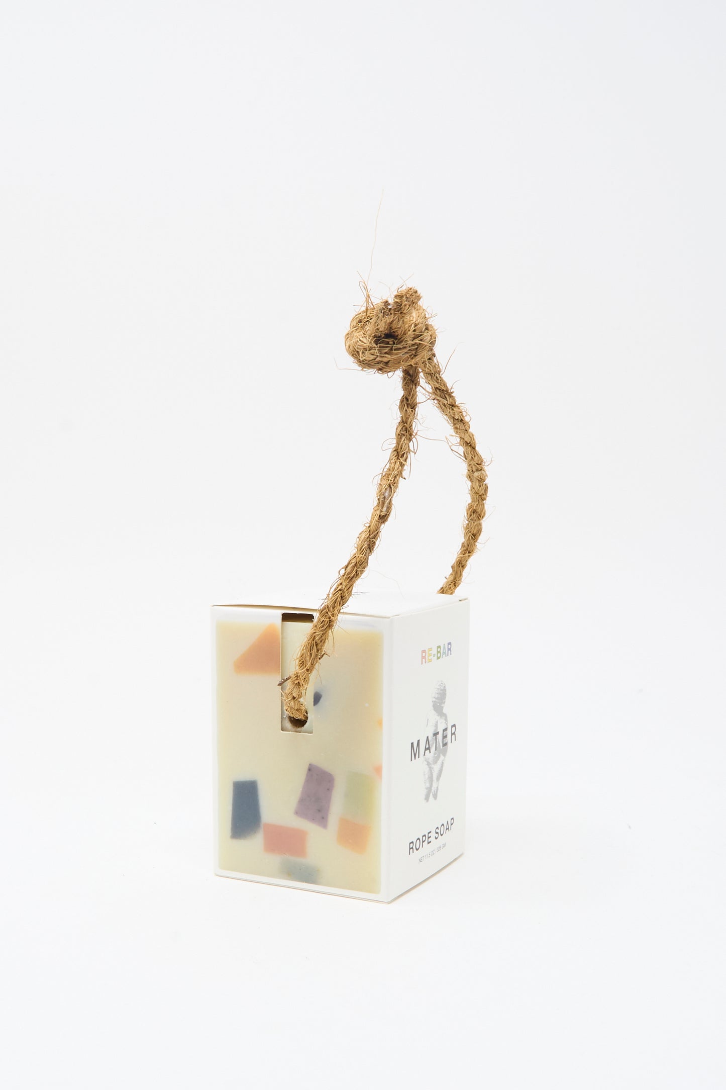 The Re-Bar Rope Soap by Mater Soap is a rectangular terrazzo bar with colorful pieces, housed in a white box and finished with a thick natural rope loop at the top.