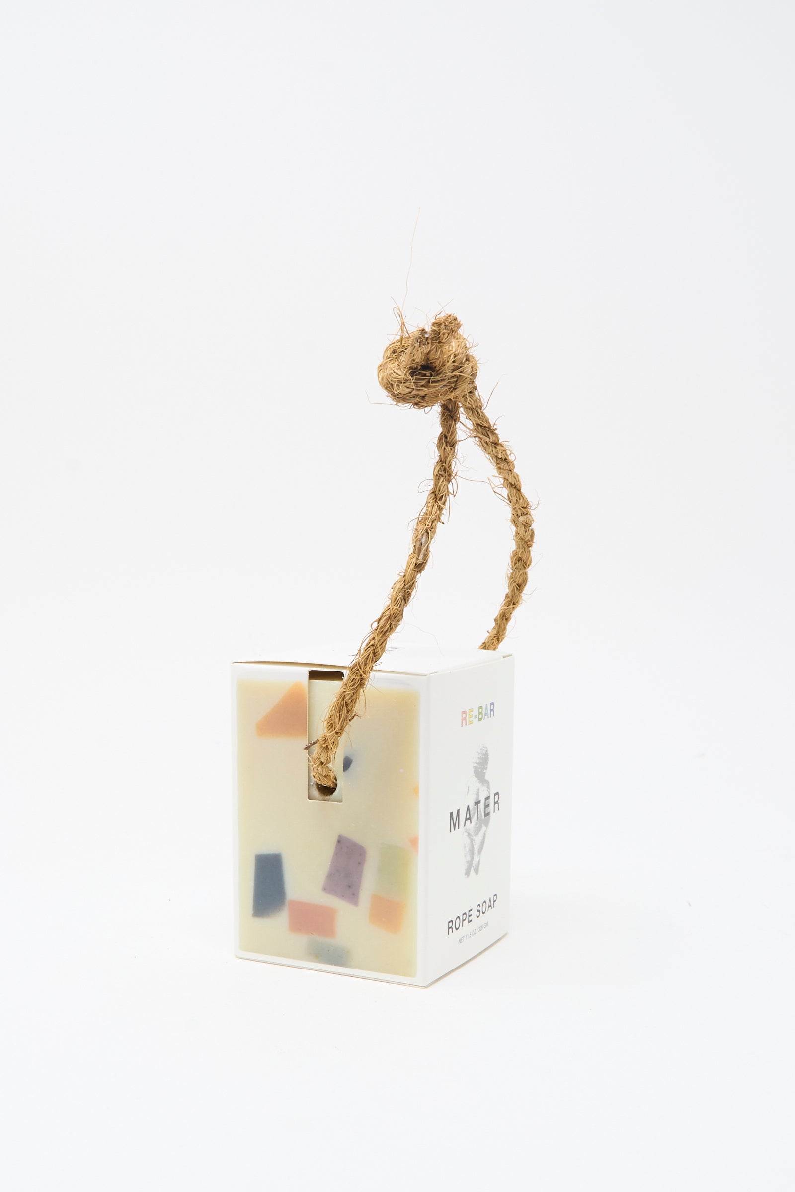 The Re-Bar Rope Soap by Mater Soap is a rectangular terrazzo bar with colorful pieces, housed in a white box and finished with a thick natural rope loop at the top.