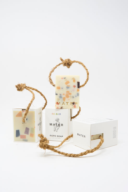 Three Re-Bar Rope Soap bars by Mater Soap, each olive-based with colorful terrazzo pieces and a sturdy twisted rope, are shown alongside their packaging.