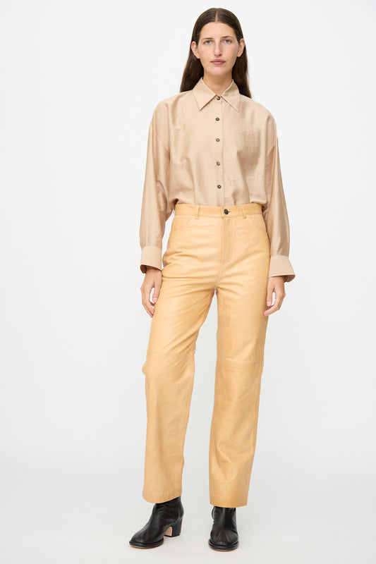 A person stands against a plain backdrop wearing the Milena Silvano Leather 5 Pocket Trousers in Bare.