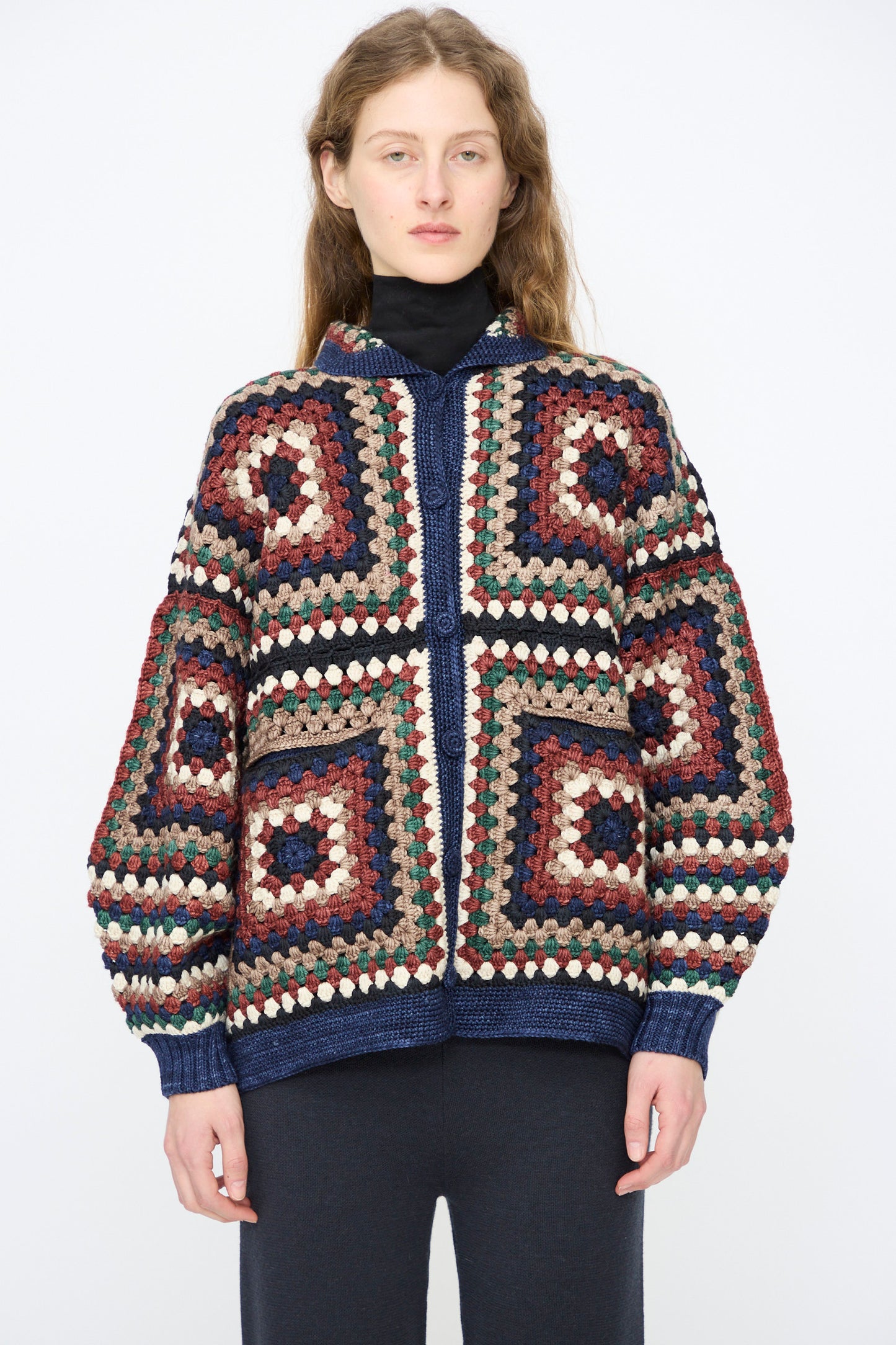 A person wears the Misha & Puff Crochet Big Square Jacket in Ink over a black top and dark pants, standing against a plain light background.