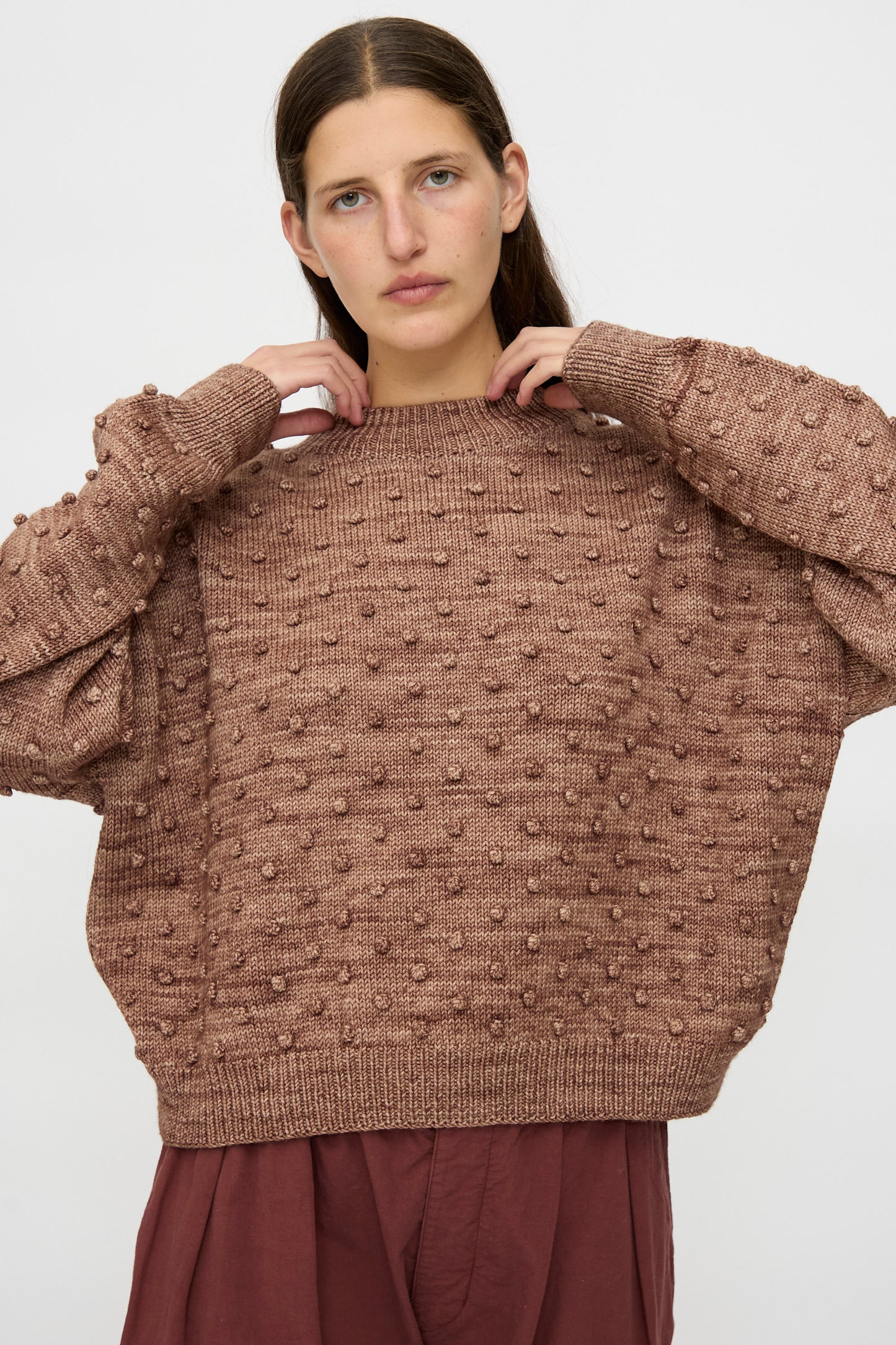 Someone wears the Misha & Puff Original Popcorn Sweater in Affogato with a matching skirt, standing against a plain light background.