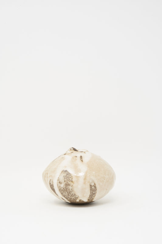 The Glazed Stoneware Mini Moon Bud Vase by MONDAYS features a round, multicolor textured surface in light beige and brown, and is displayed centered on a plain white background.