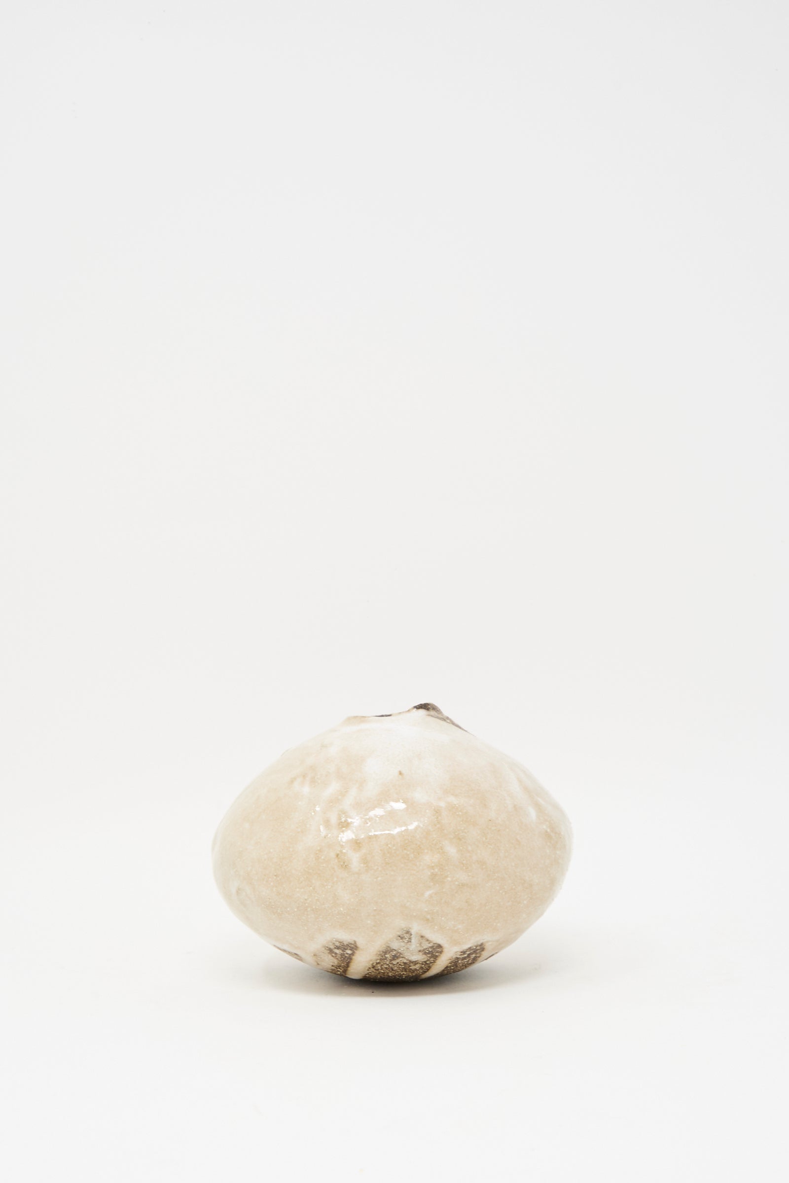 The MONDAYS Glazed Stoneware Mini Moon Bud Vase, featuring a single round beige form with a narrow opening, is centered on a plain white background, highlighting the elegance of handcrafted design.