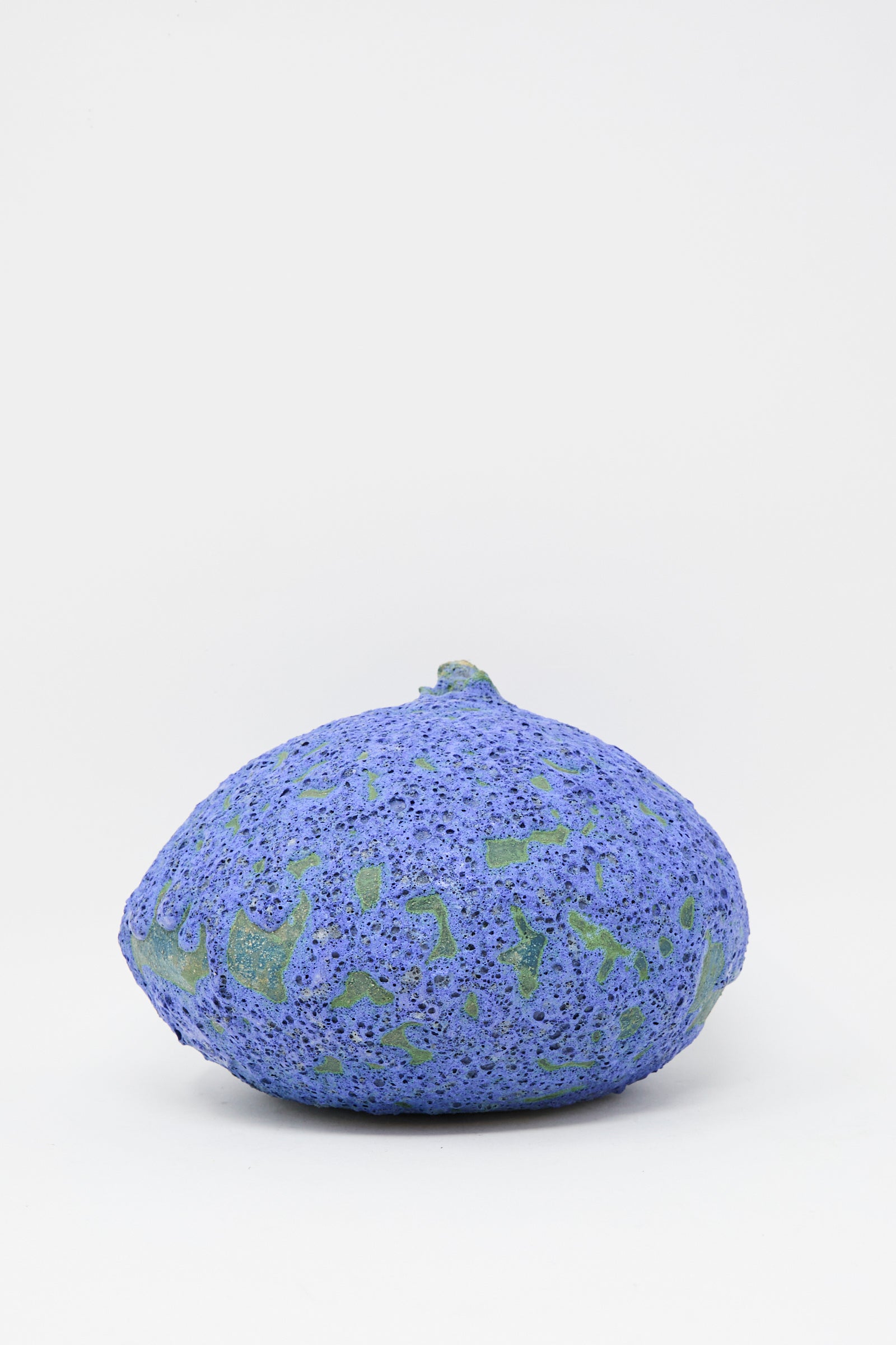 The MONDAYS Glazed Stoneware Moon Vase in Blue, with its round, textured form inspired by moon vase tradition, sits on a plain white background—its handmade look and blue glaze lending it distinctive character.