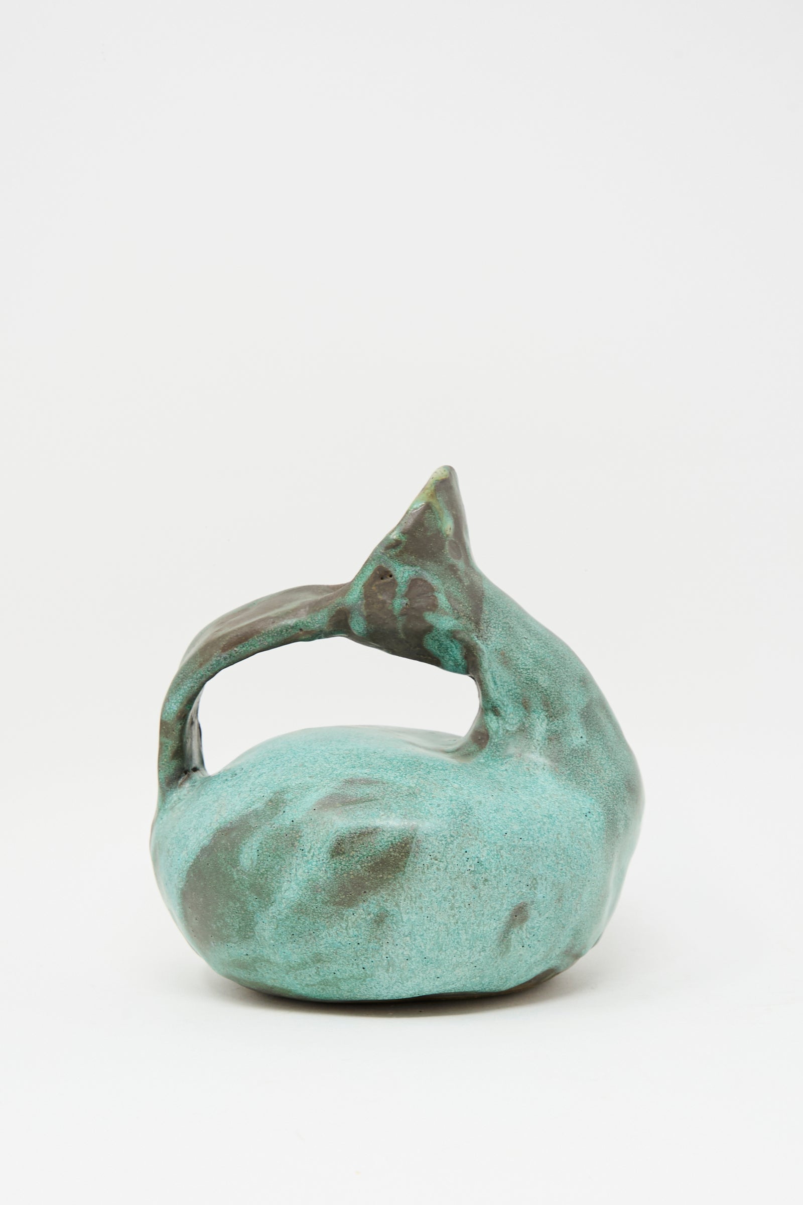 The MONDAYS Glazed Stoneware Pitcher Vase in Green features a hand-built, curved design with an arching handle and a green glazed finish, evoking the look of an abstract ceramic sculpture.
