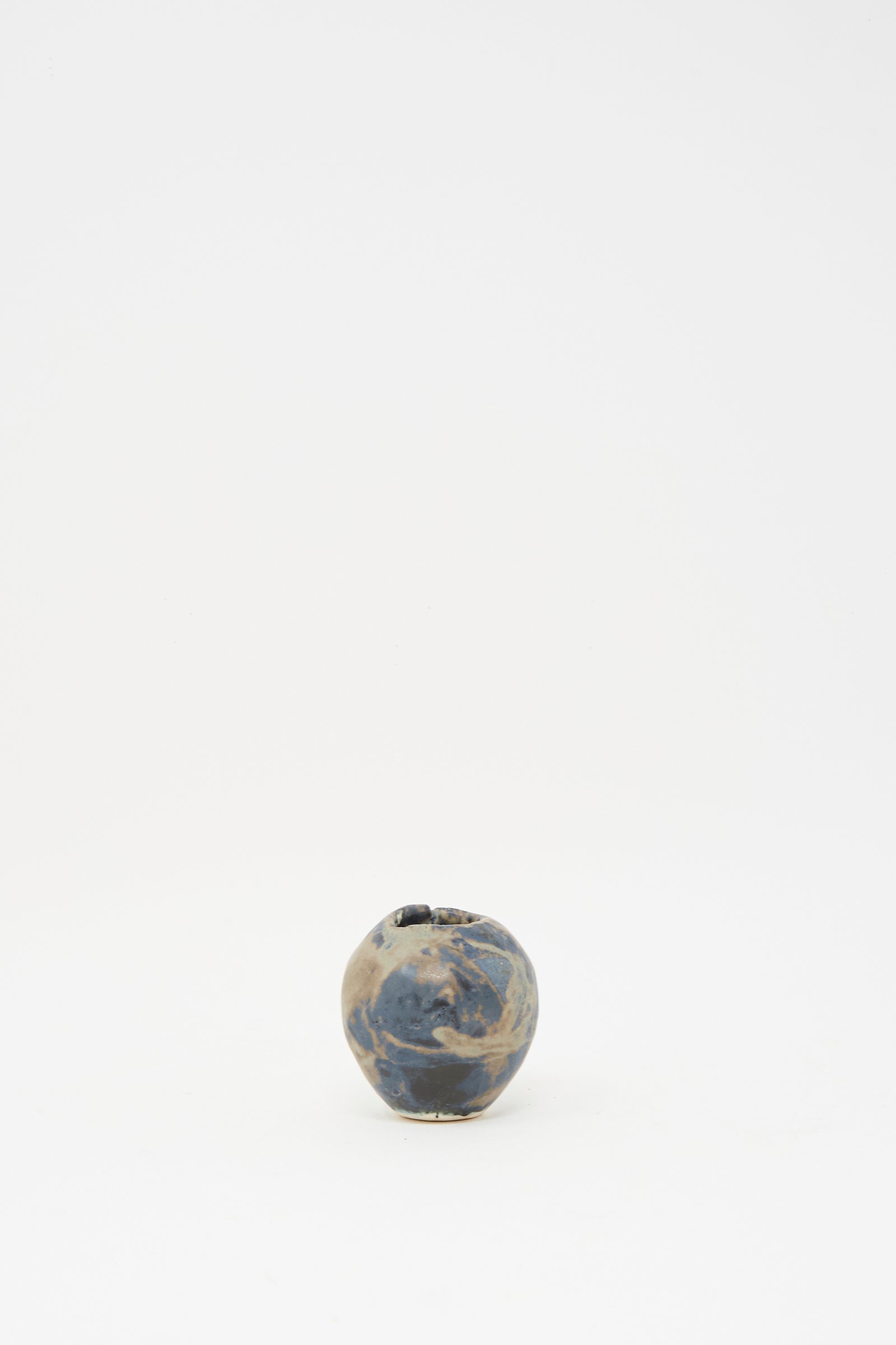 The MONDAYS Mini Bud Vase I, hand-built in porcelain with a marbled blue and beige glaze, is displayed centered on a plain white background.