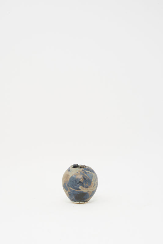 The MONDAYS Mini Bud Vase I, hand-built in porcelain with a marbled blue and beige glaze, is displayed centered on a plain white background.