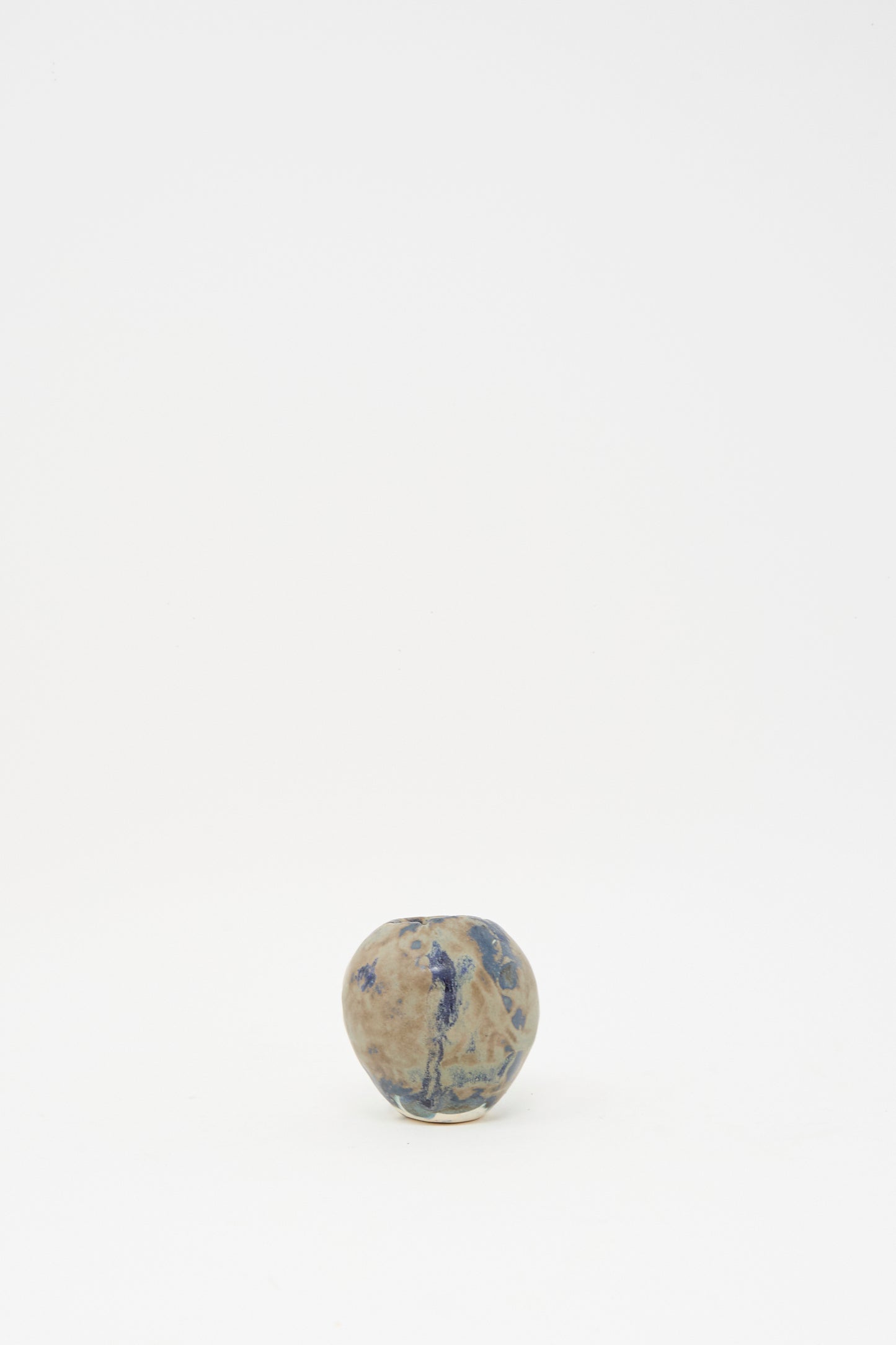 The MONDAYS Mini Bud Vase I, a small round hand-built porcelain vase featuring blue and brown patterns, is centered against a plain white background.