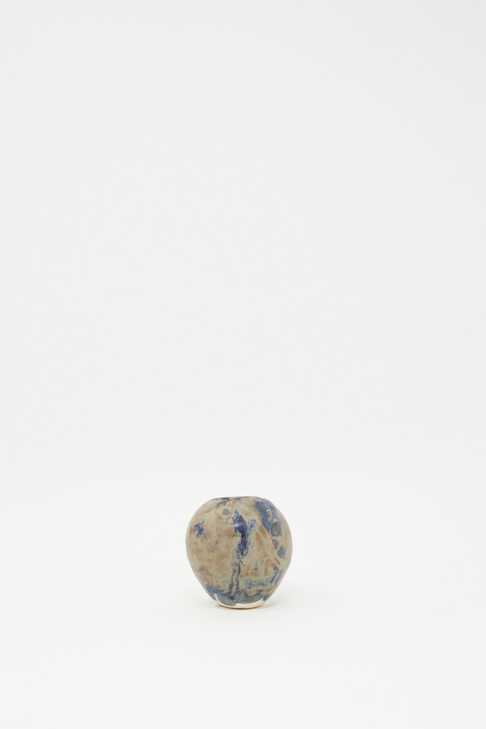 The MONDAYS Mini Bud Vase I, a small round hand-built porcelain vase featuring blue and brown patterns, is centered against a plain white background.