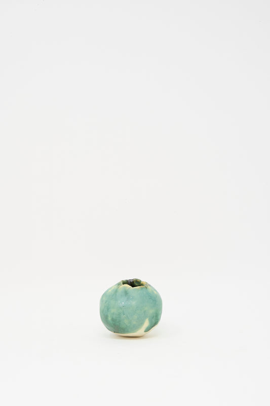 The MONDAYS Mini Bud Vase II, featuring a small round shape and green glaze porcelain finish, is displayed centered on a plain white background.