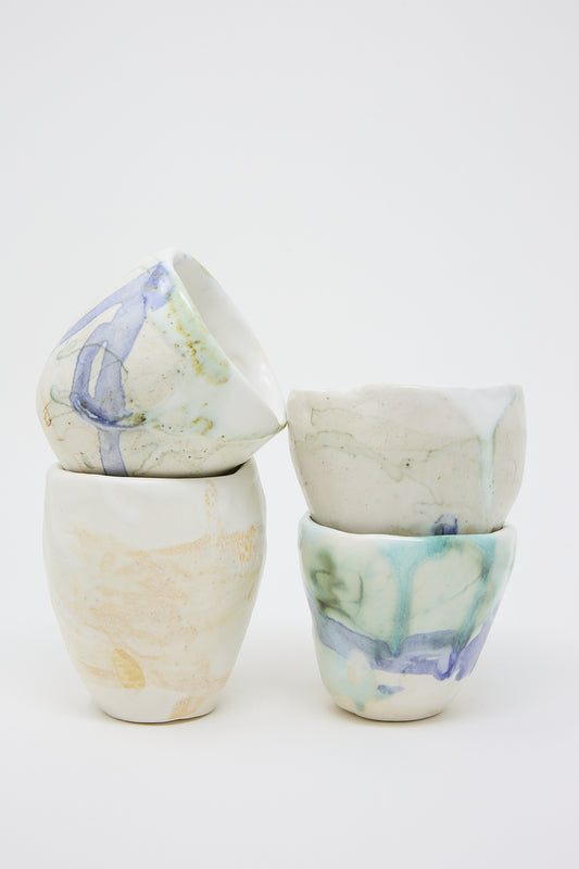 Three textured glazed MONDAYS porcelain tumblers with different colors of paint on them.