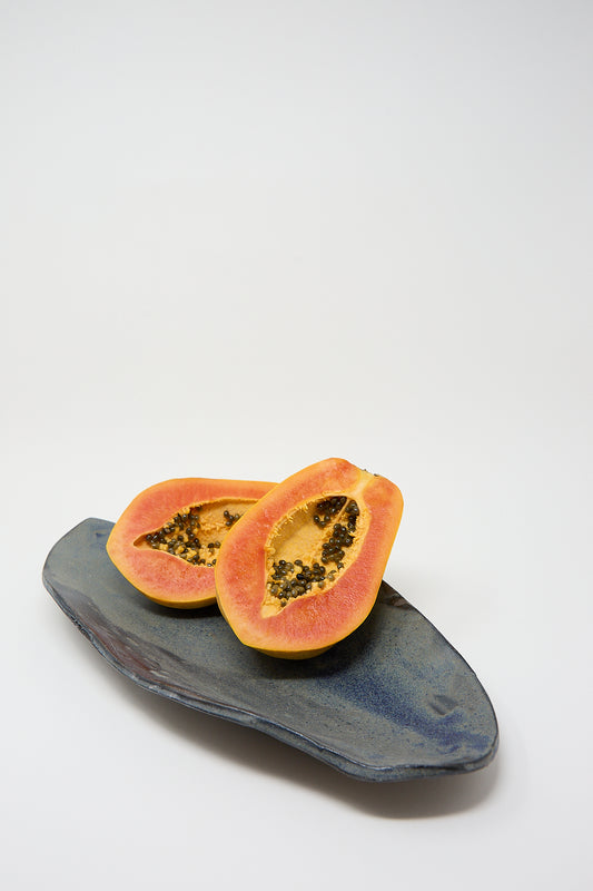 A Shell Platter in Blue Glaze on Dark Brown Clay with two handmade papayas on it by MONDAYS.