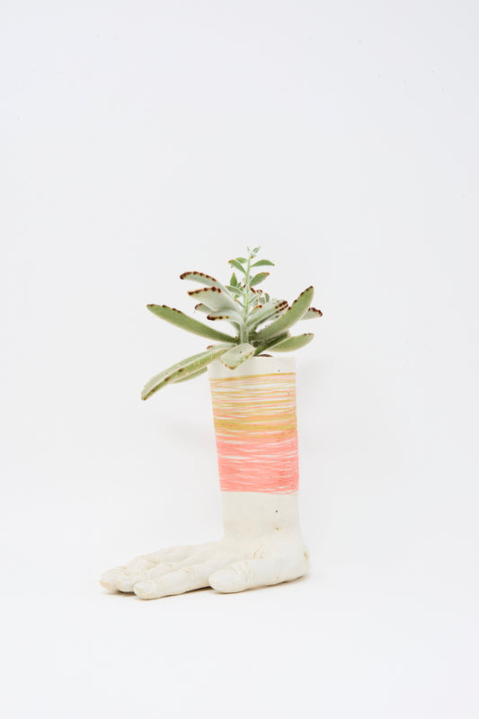 The Monty J Ceramic Hand Sculpture, wrapped with pink and gold thread, features a small succulent and is handmade in Brooklyn, displayed against a plain white background.