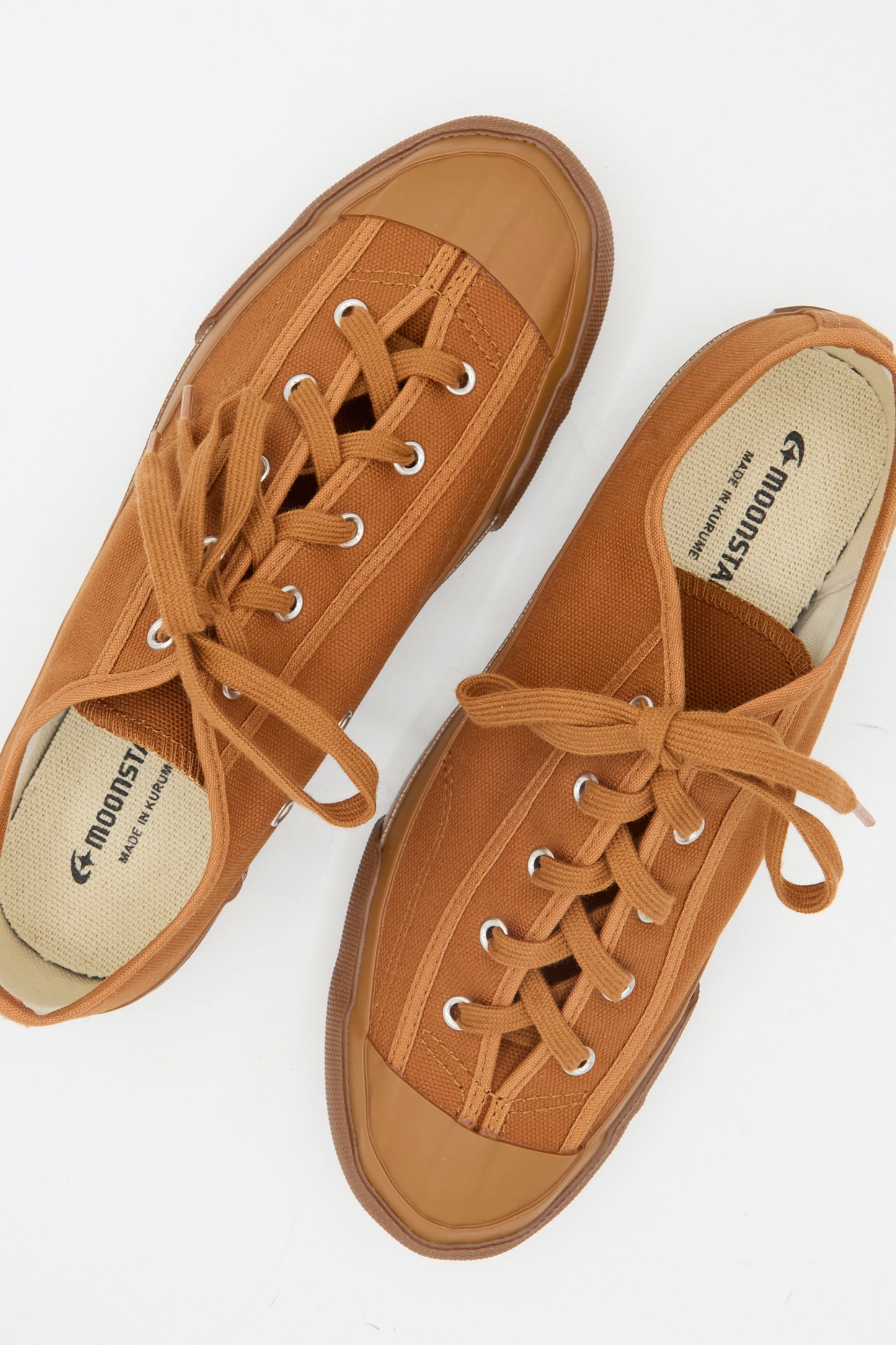 The Moonstar Gym Classic Sneaker in Brick, a pair of Japanese-made canvas sneakers with rubber toes and laces, is displayed from above on a white background.