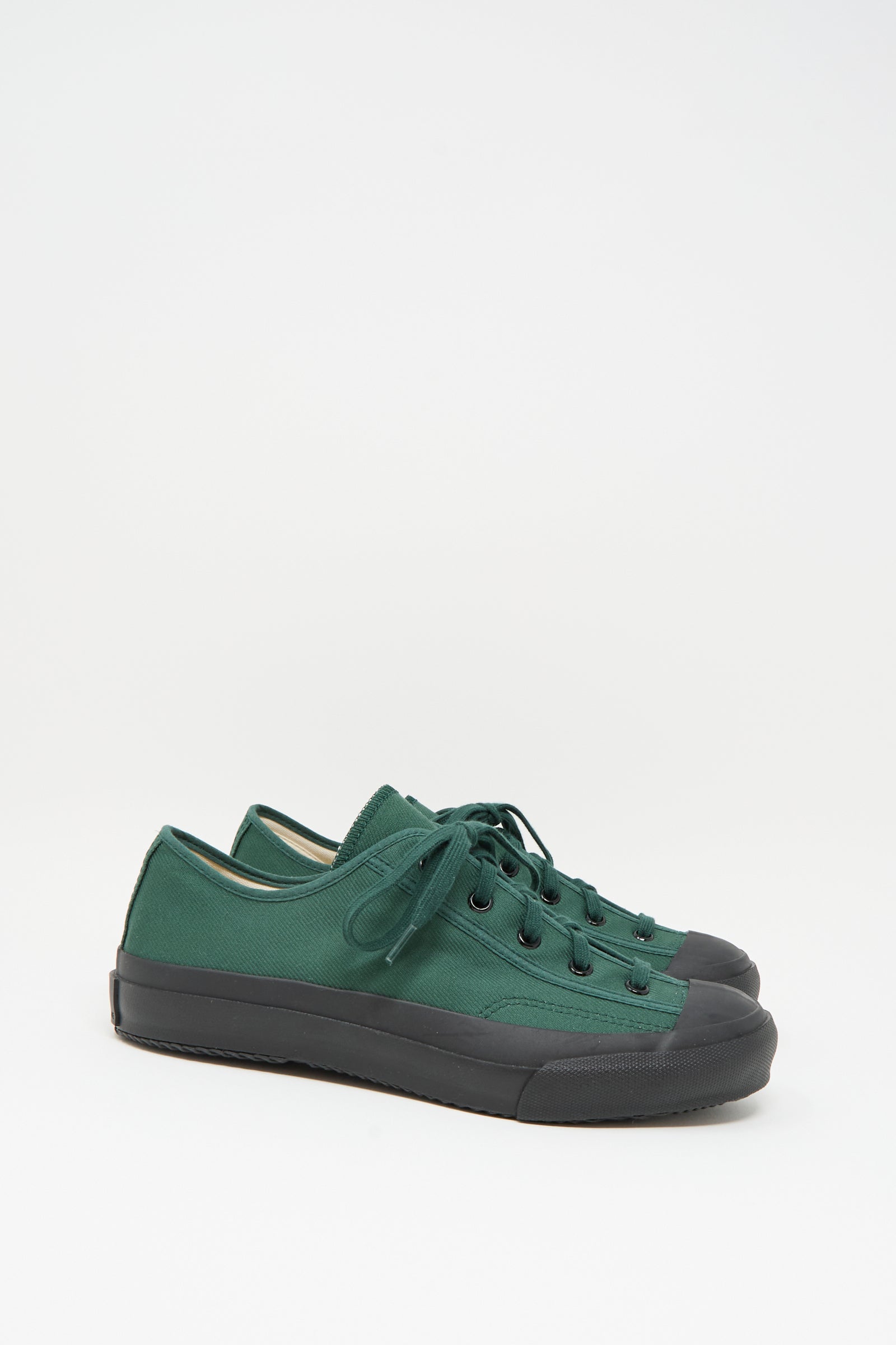 The Moonstar Gym Classic Sneaker in Dark Green is a Japanese-made low-top canvas shoe with black rubber soles and toe caps, shown on a plain white background.