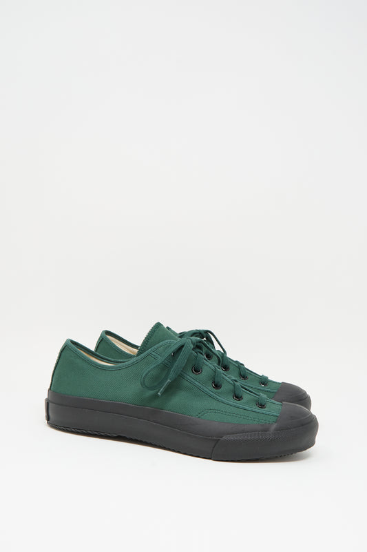 The Moonstar Gym Classic Sneaker in Dark Green is a Japanese-made low-top canvas shoe with black rubber soles and toe caps, shown on a plain white background.