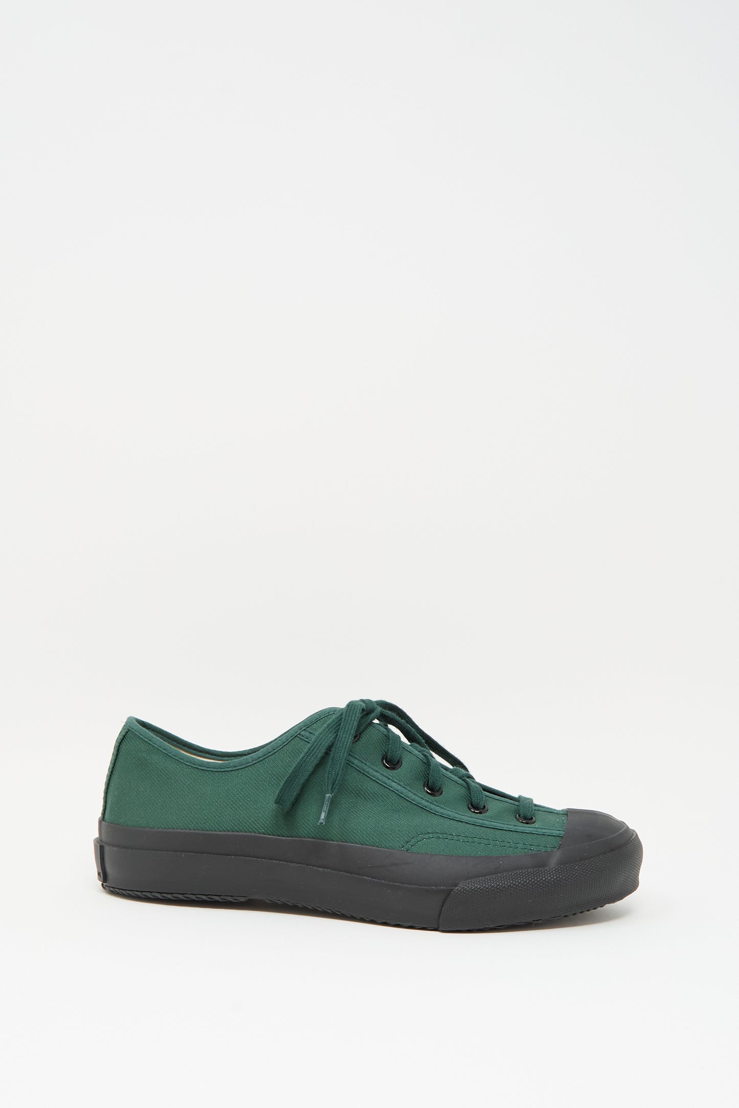 The Moonstar Gym Classic Sneaker in Dark Green features black laces, a black rubber toe cap, and a black sole. Made in Japan, it is showcased against a plain white background.