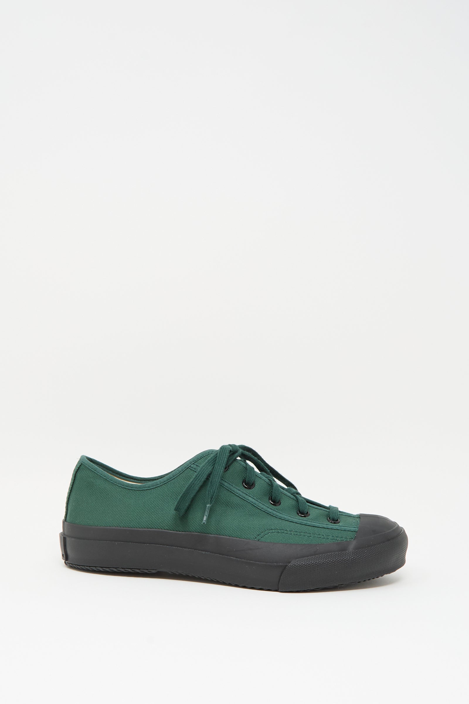 The Moonstar Gym Classic Sneaker in Dark Green features black laces, a black rubber toe cap, and a black sole. Made in Japan, it is showcased against a plain white background.