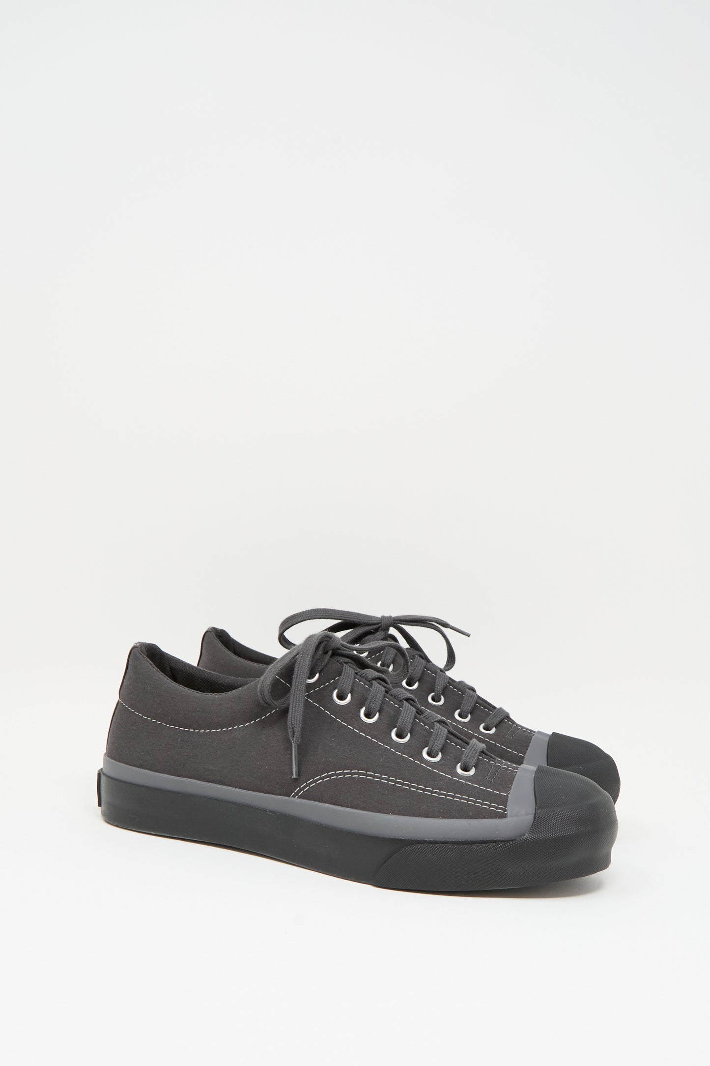 The Moonstar Gym Court Sneaker in Charcoal is a low top, made in Japan from durable cotton nylon canvas with rubber toe caps and black laces, shown against a white background.