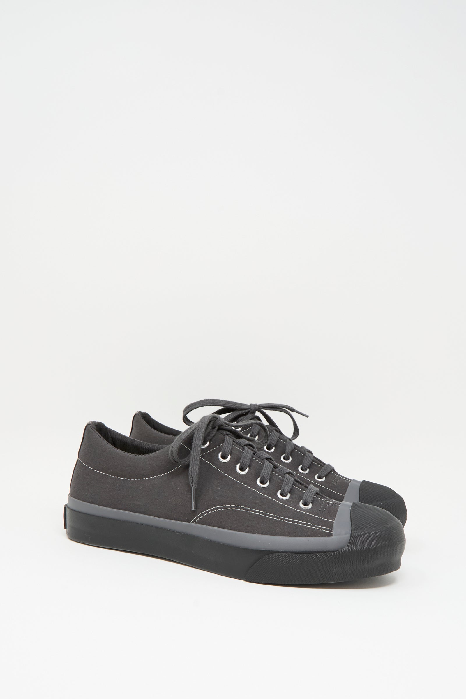 The Moonstar Gym Court Sneaker in Charcoal is a low top, made in Japan from durable cotton nylon canvas with rubber toe caps and black laces, shown against a white background.