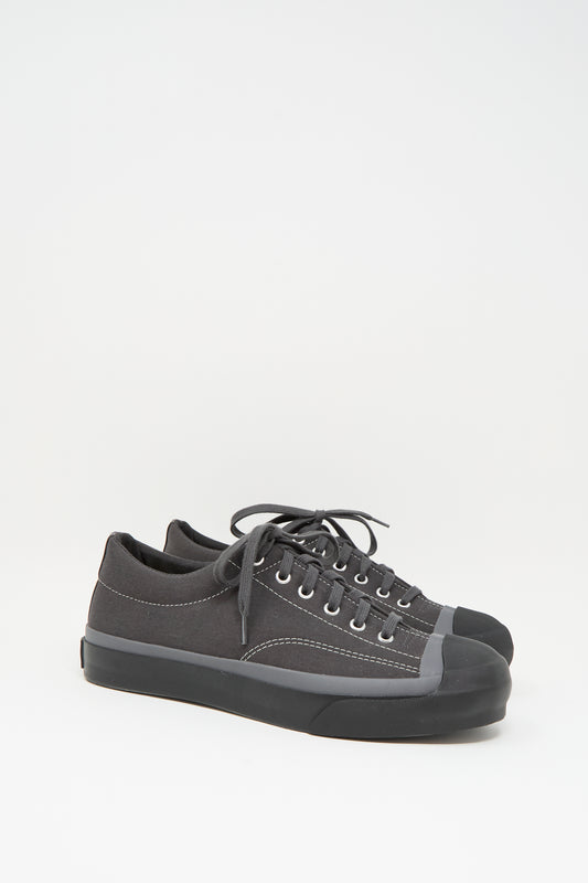 The Moonstar Gym Court Sneaker in Charcoal is a low top, made in Japan from durable cotton nylon canvas with rubber toe caps and black laces, shown against a white background.