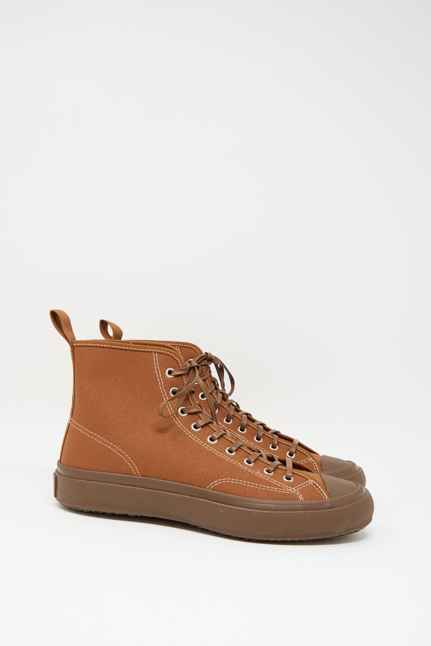 The Moonstar Hi Basket Sneaker in Brown is a vintage-inspired high top with canvas uppers, rubber soles and toe caps, metal eyelets, and brown laces, shown against a white background.