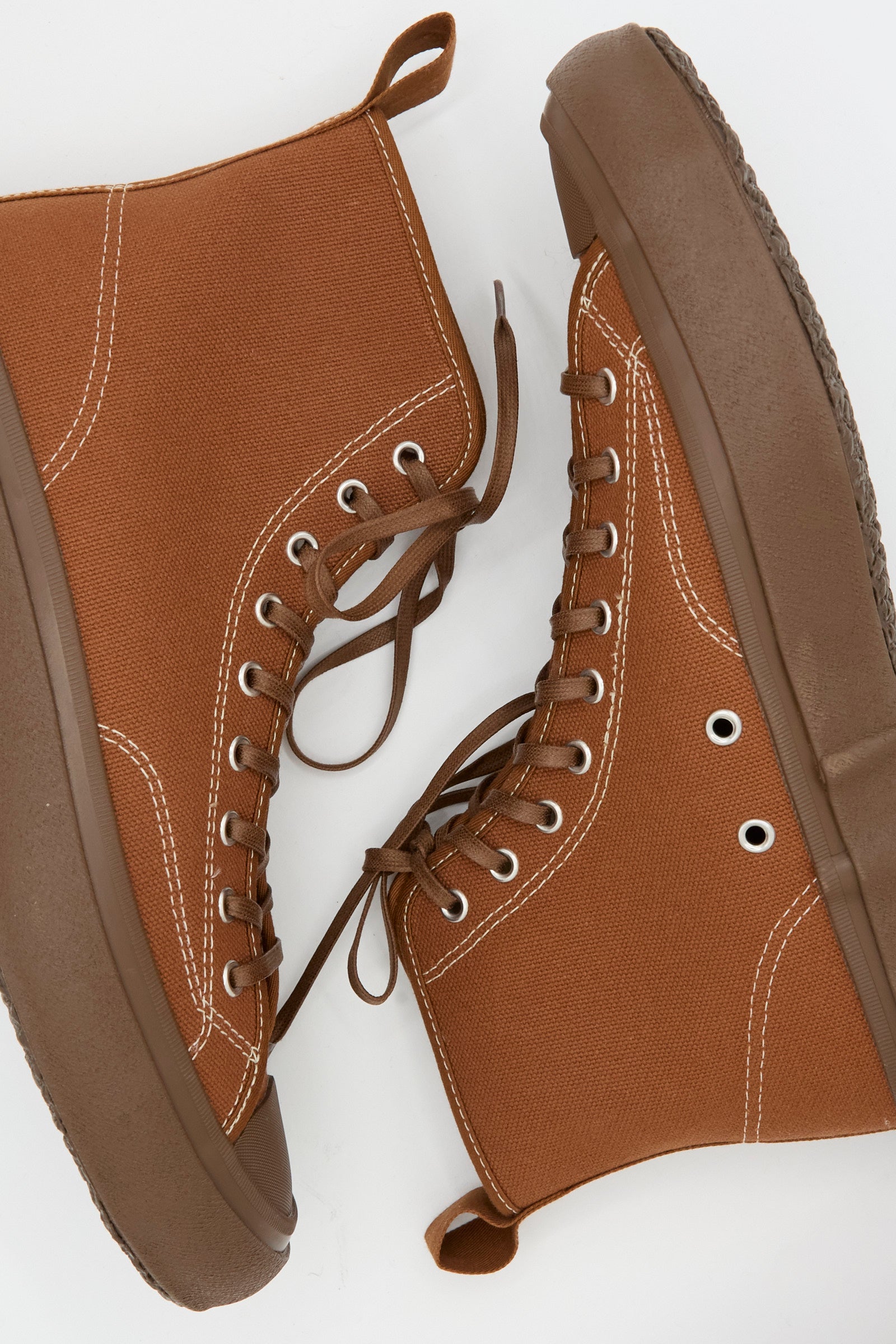 The Moonstar Hi Basket Sneaker in Brown features a vintage-inspired canvas high-top design with white stitching and brown rubber soles, shown side by side on a white background.