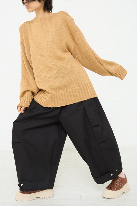 A woman wearing a camel sweater and Niccolò Pasqualetti's Cotton Twill Luna Trouser in Black. Front view.