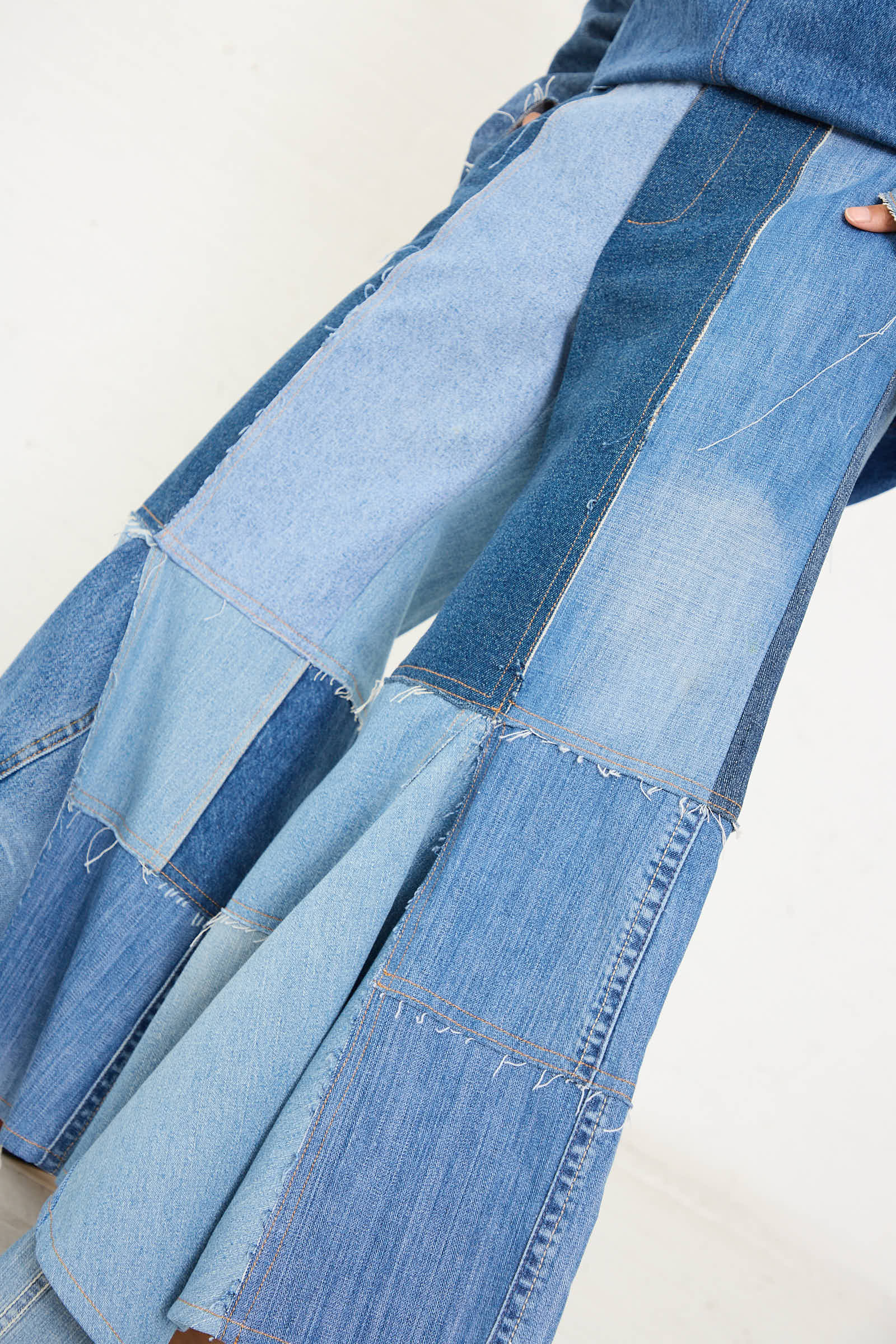 Close-up of the Salvaged Jean Patchwork Lengo Trouser in Blue by Niccolò Pasqualetti, a mid-rise design crafted with patchwork denim in various shades of blue and featuring a stylish, wide-leg silhouette.